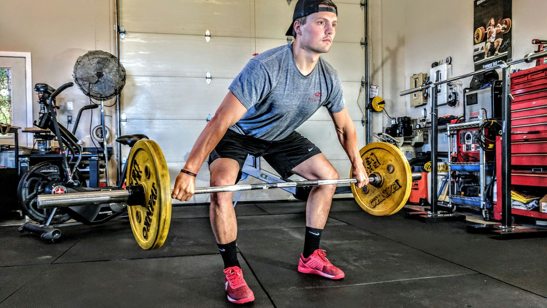 man carrying yellow barbell