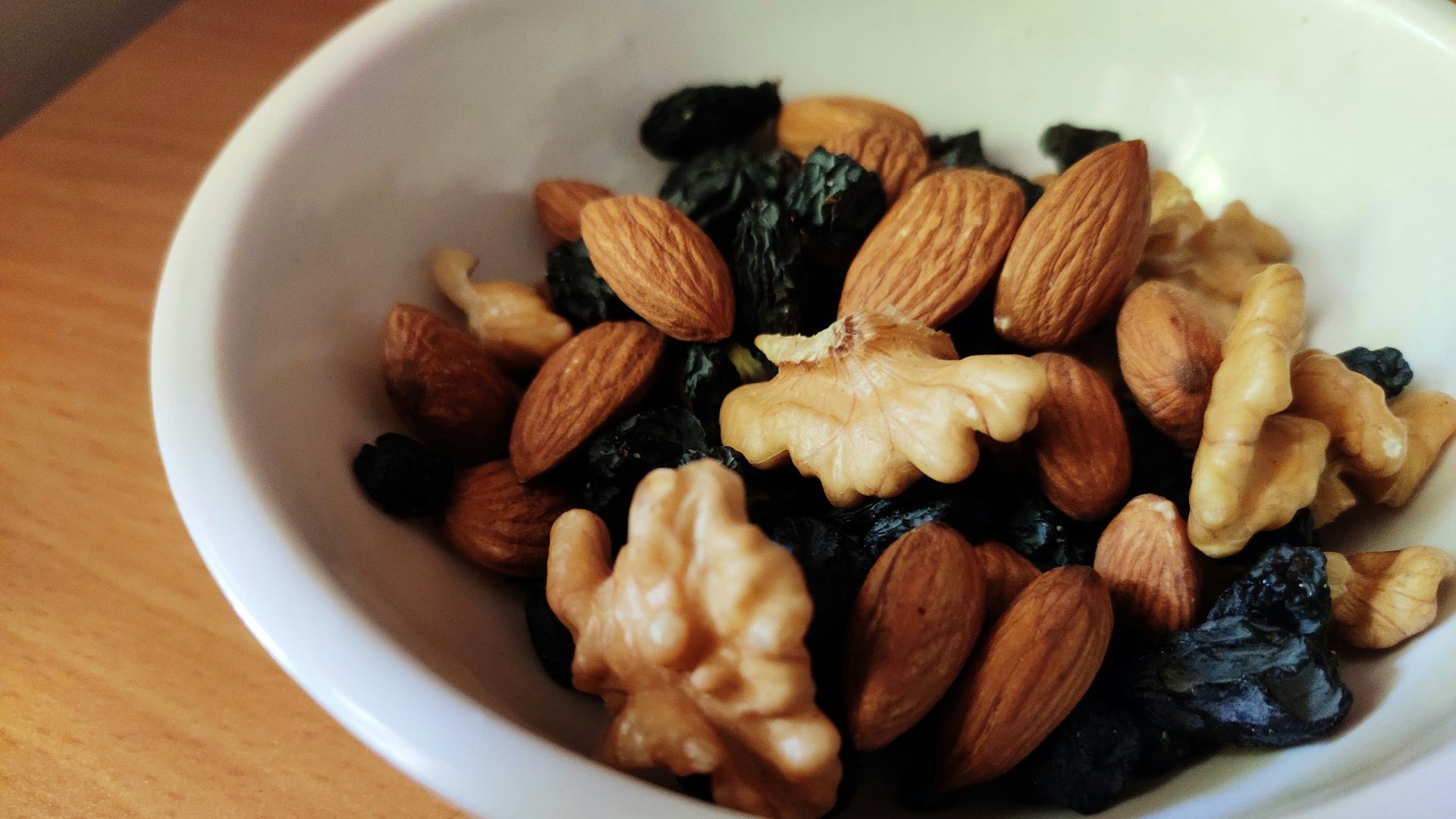 brown and black nuts on white ceramic bowl