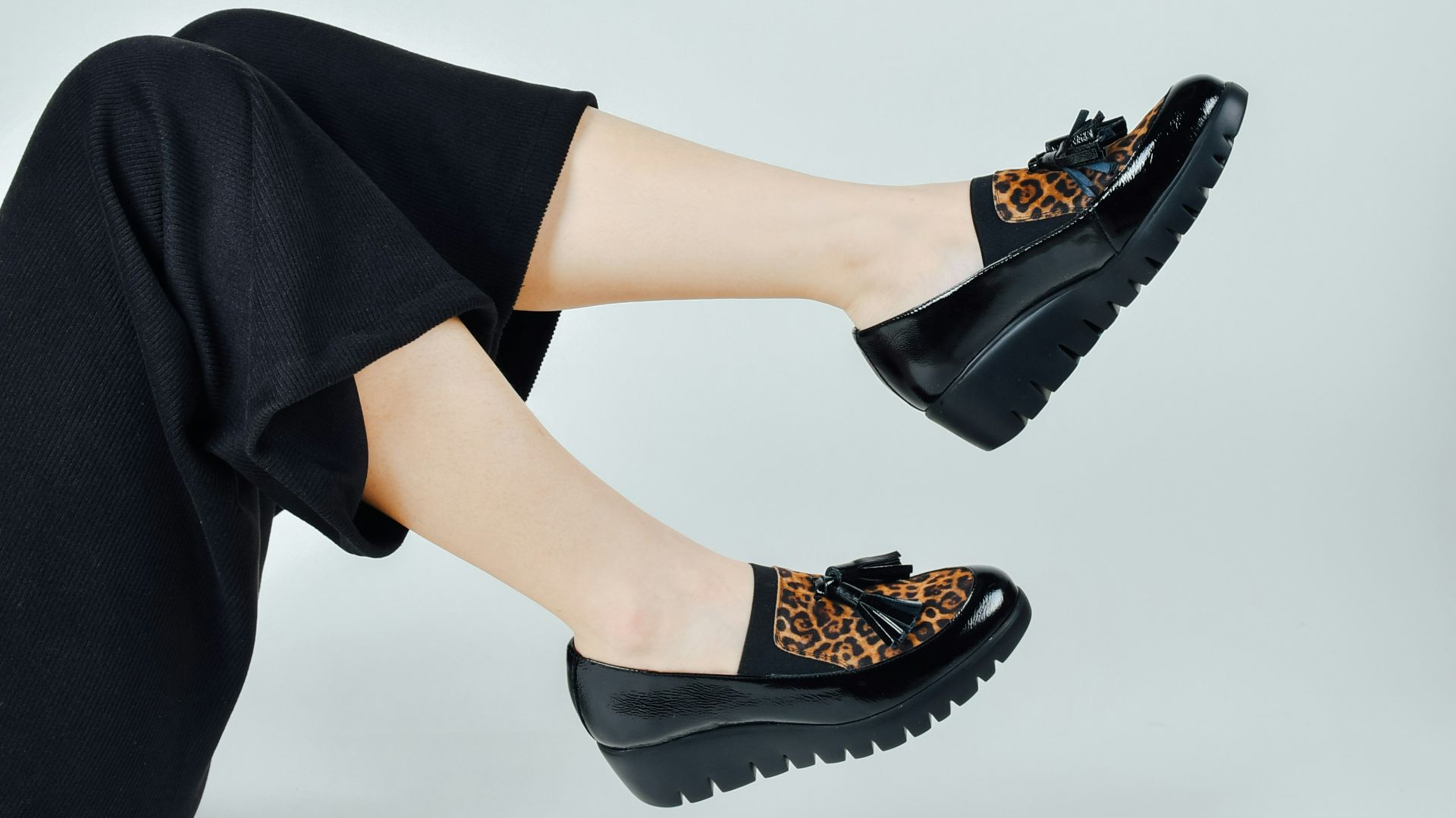 woman in black pants wearing black leather peep toe heeled shoes