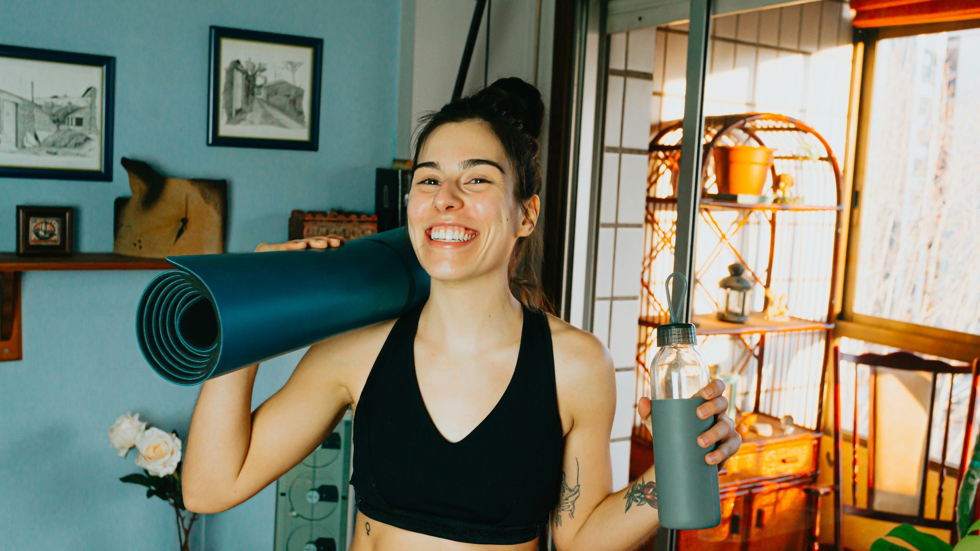 woman in black sports bra holding blue and black kettle