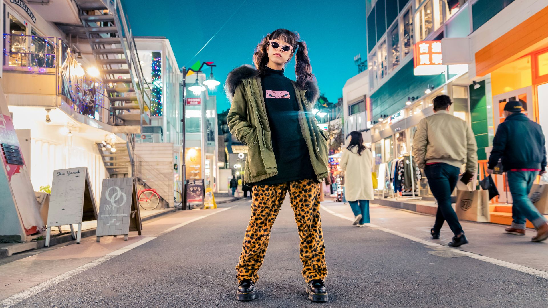 woman in green jacket stands and pose on street