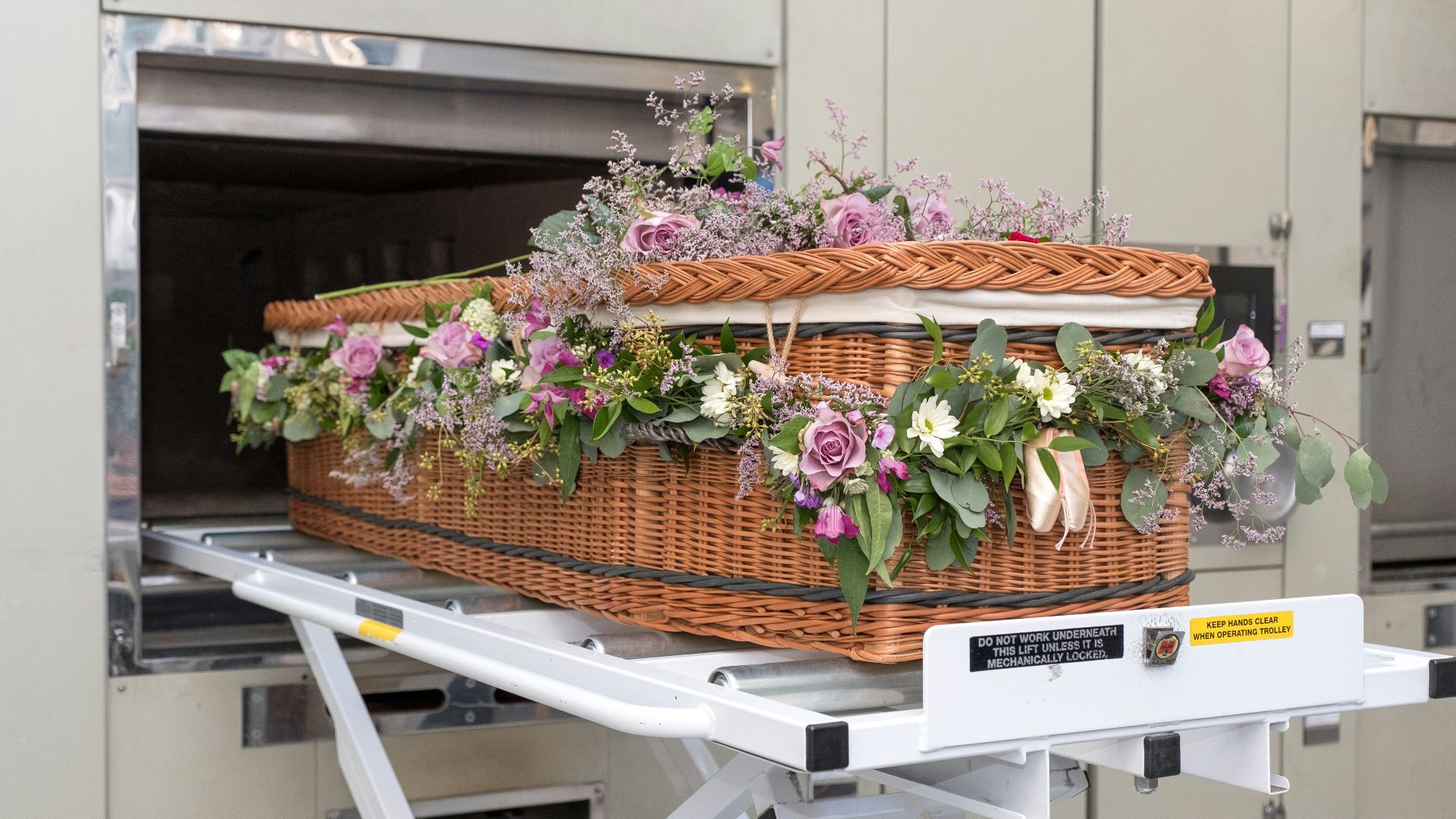 a wicker basket with flowers in it on a conveyor belt