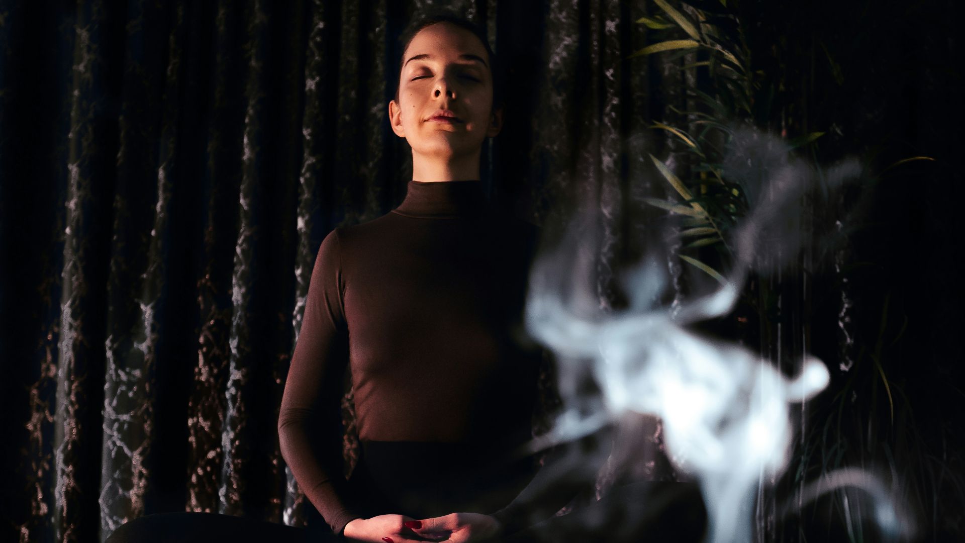 topless man sitting on bench with fire in front