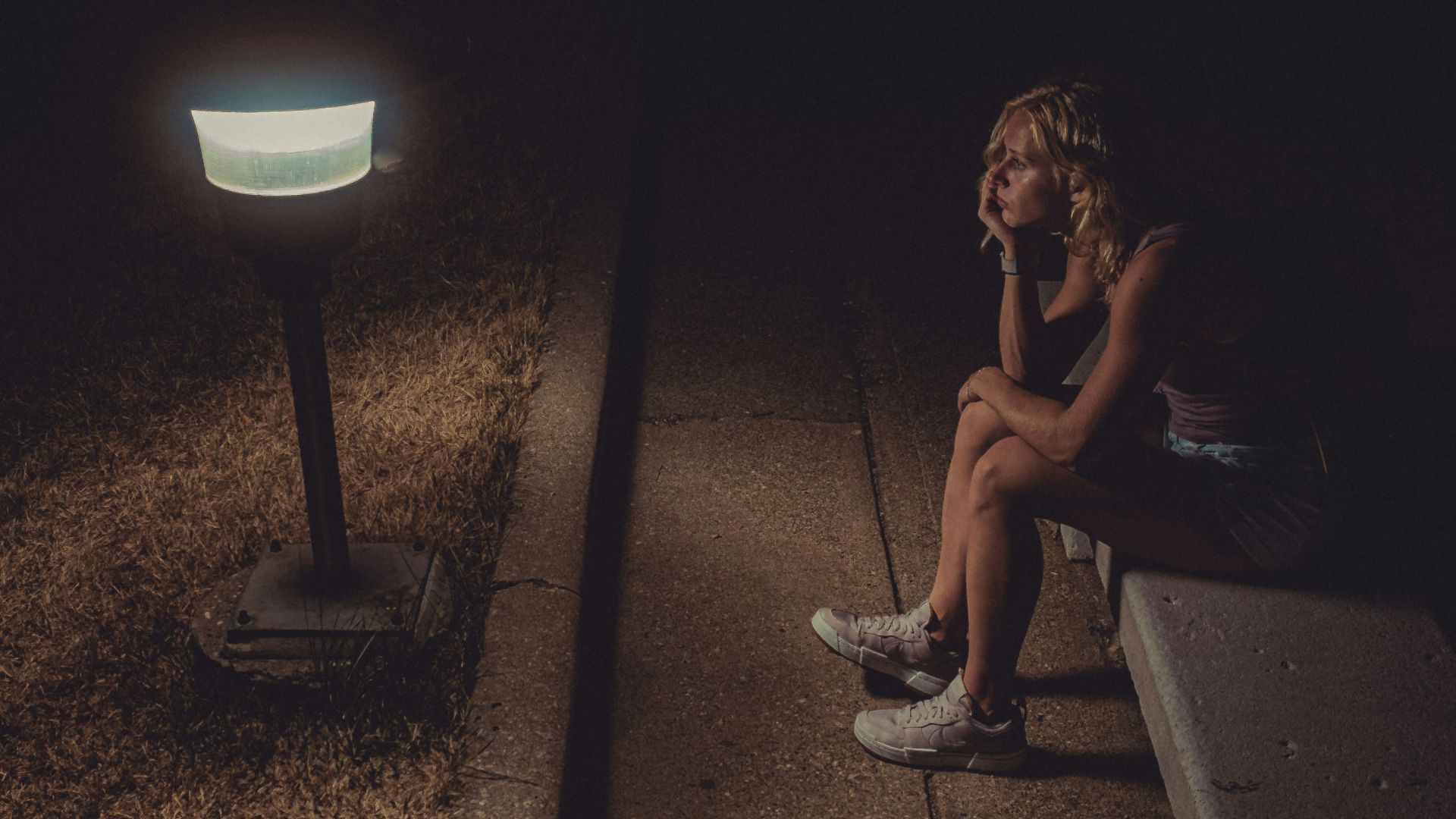 woman in black tank top sitting on concrete floor