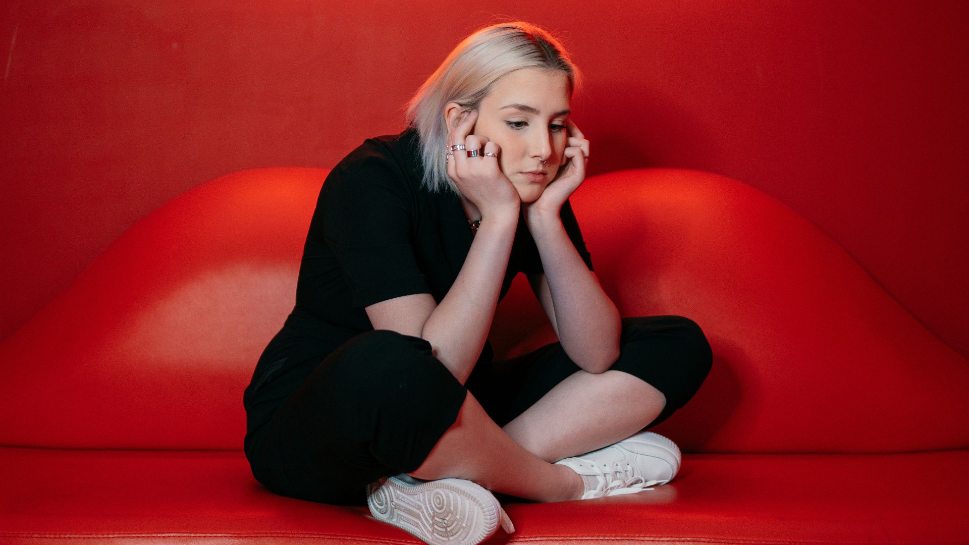 woman in black long sleeve shirt and black pants sitting on red couch
