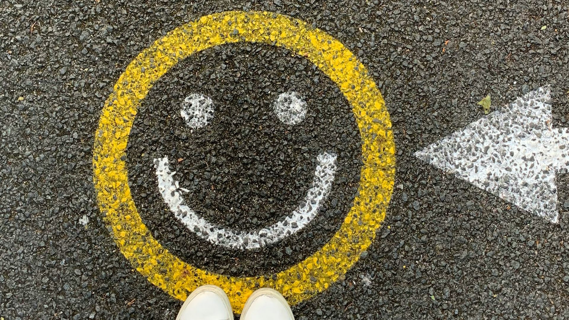 person in white shoes standing on gray concrete road