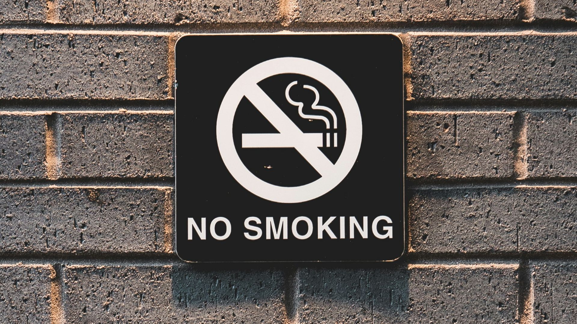 no smoking sign on brick wall