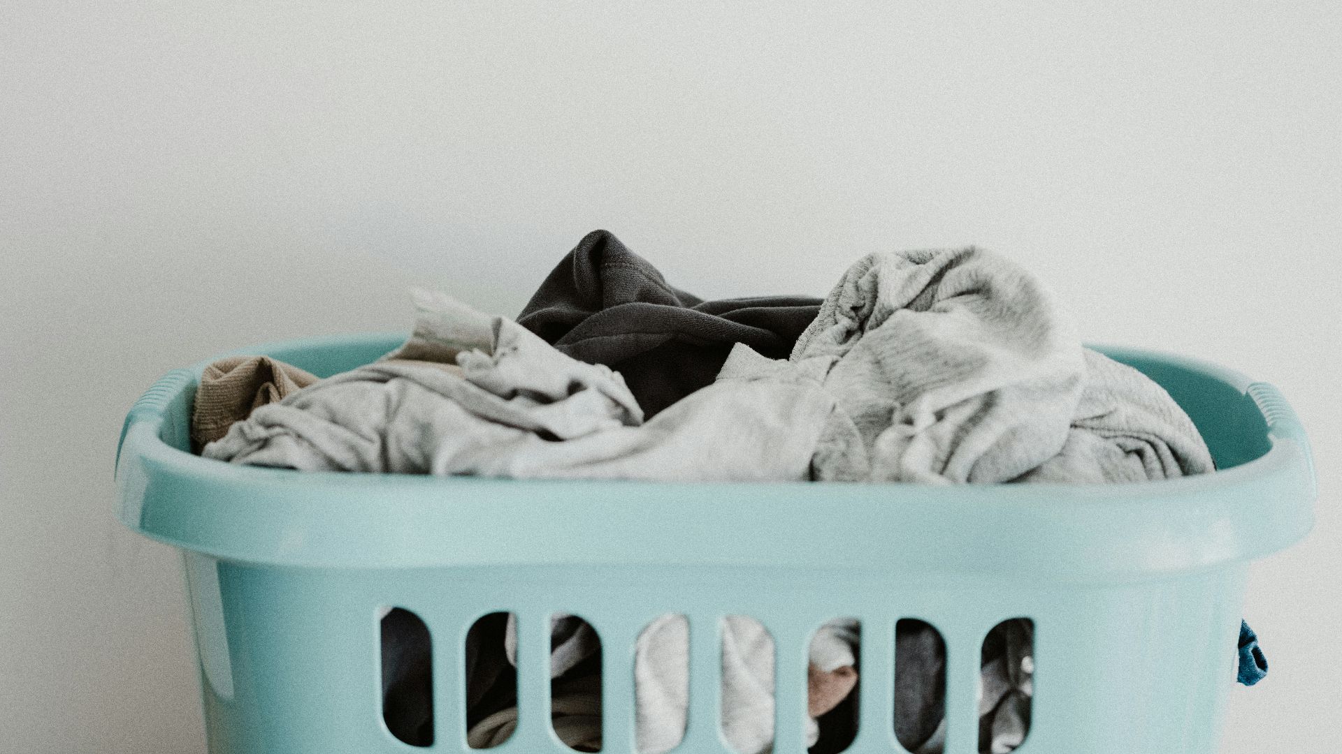 white textile on blue plastic laundry basket
