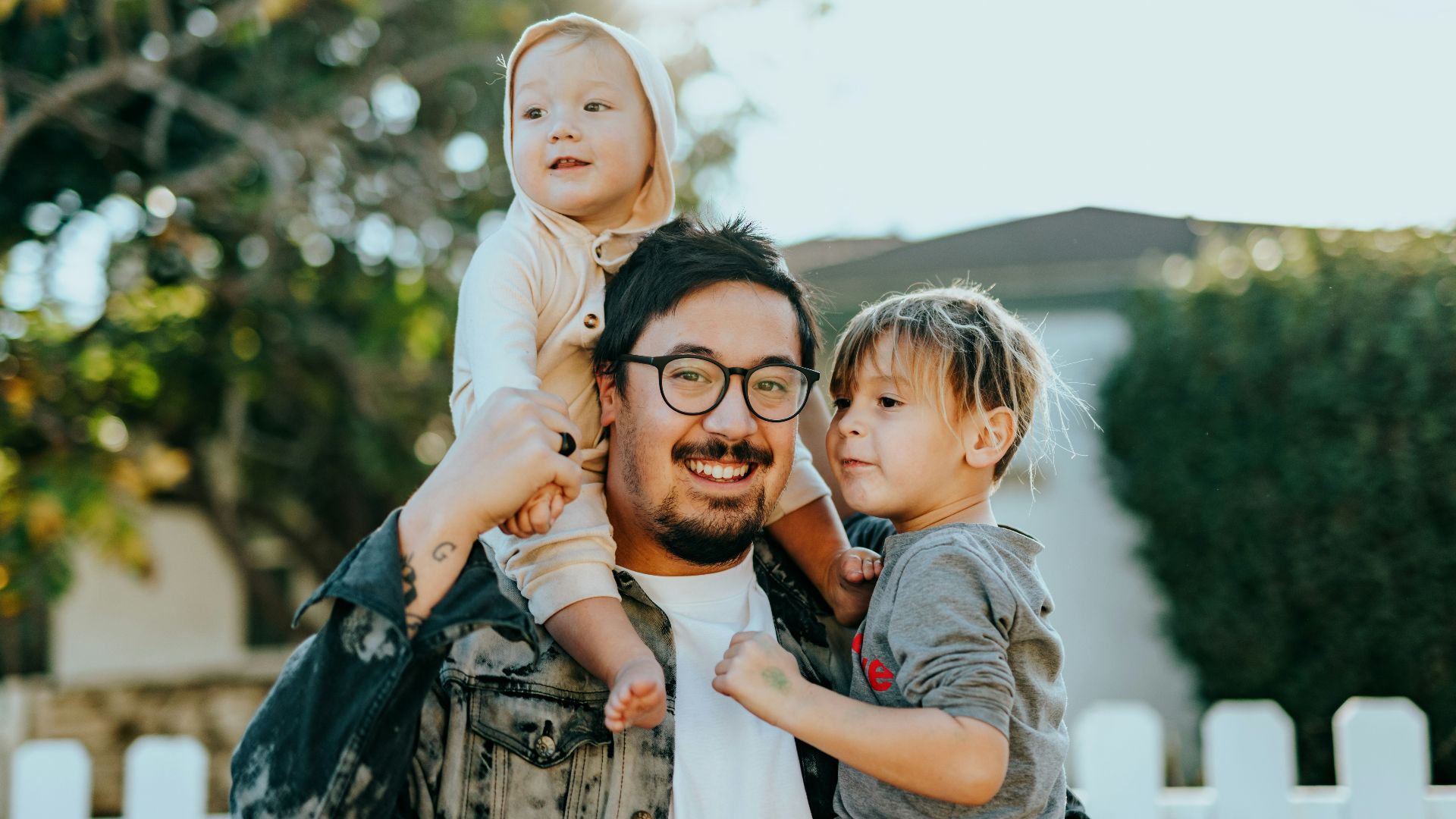 man in white shirt carrying girl in gray shirt