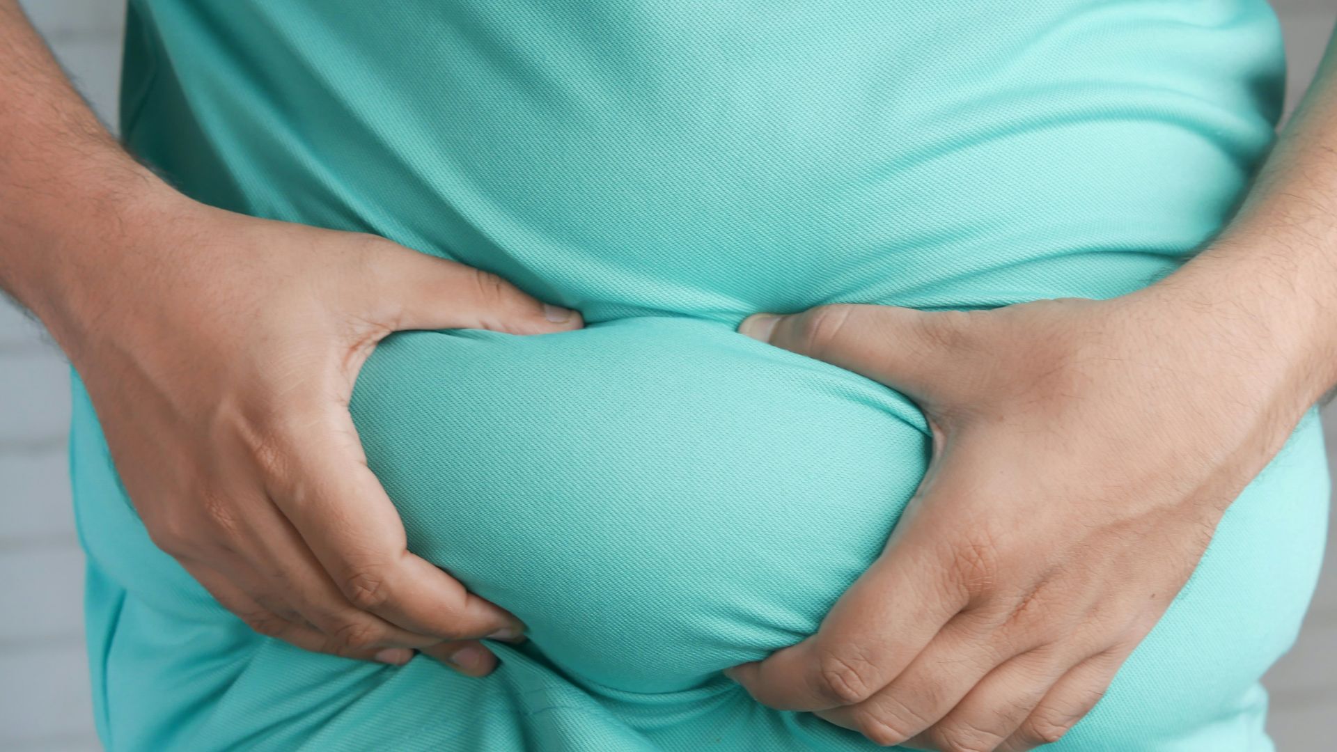 a man holding his stomach with his hands