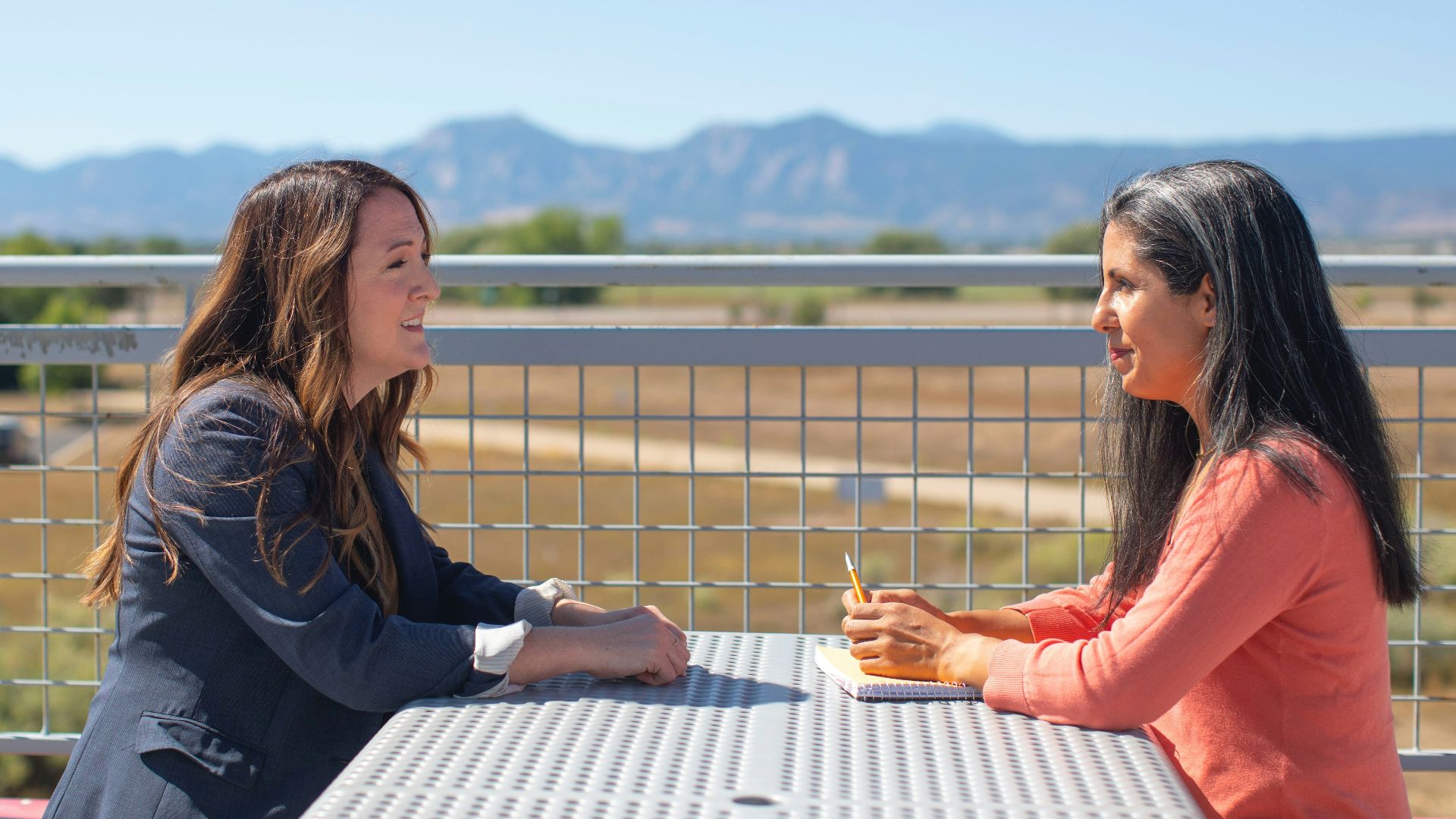 woman in black long sleeve shirt sitting on white wooden bench during daytime