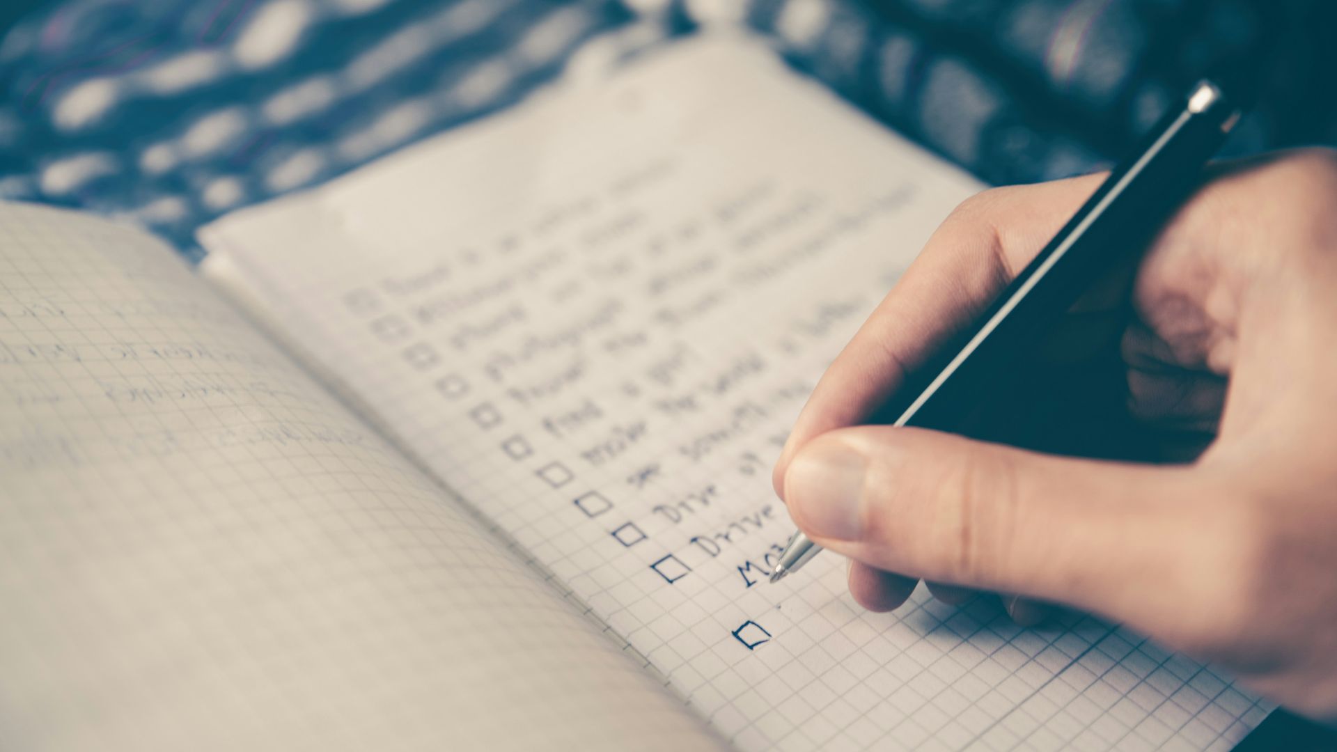 person writing bucket list on book