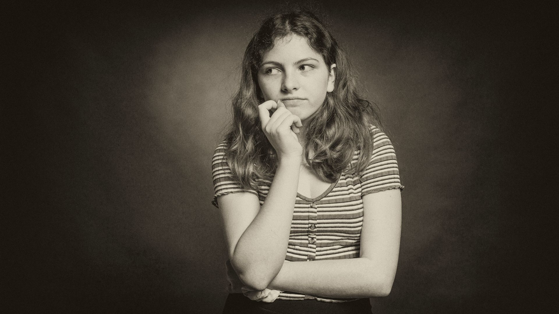 woman in stripe shirt covering her mouth with her hand