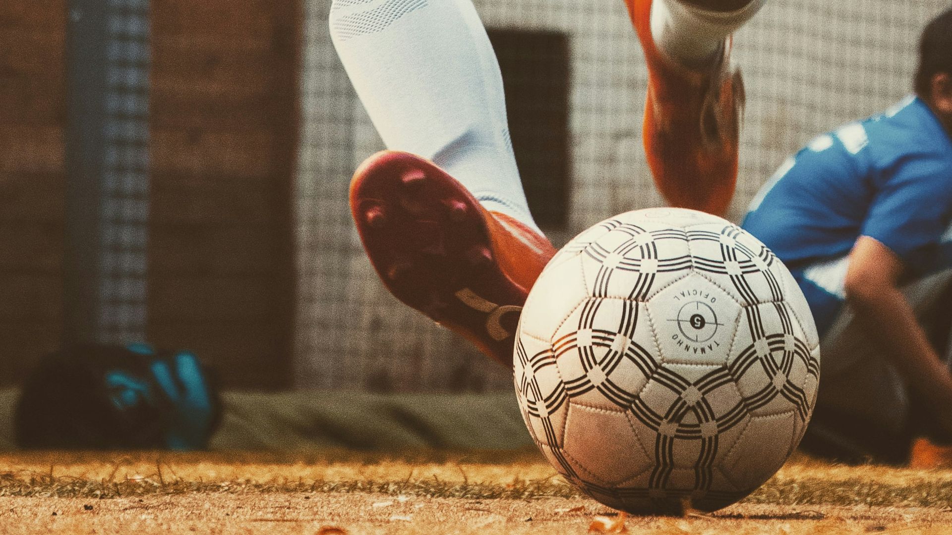person in white and red soccer jersey kicking soccer ball