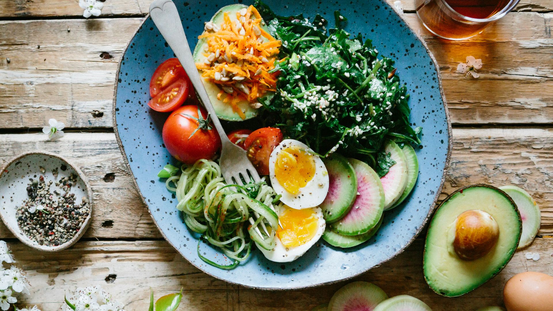 poached egg with vegetables and tomatoes on blue plate