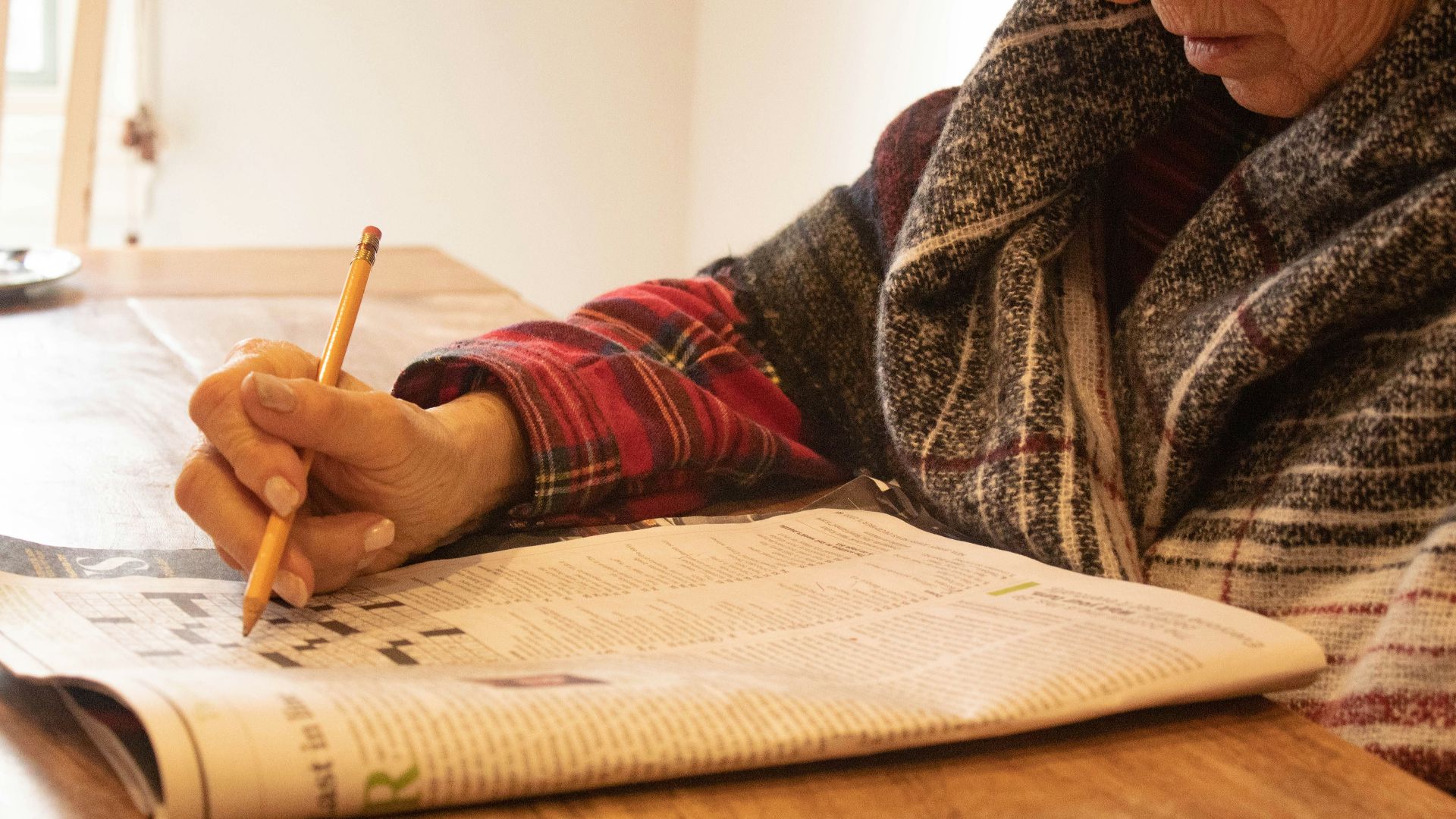 person in black and white sweater writing on white paper