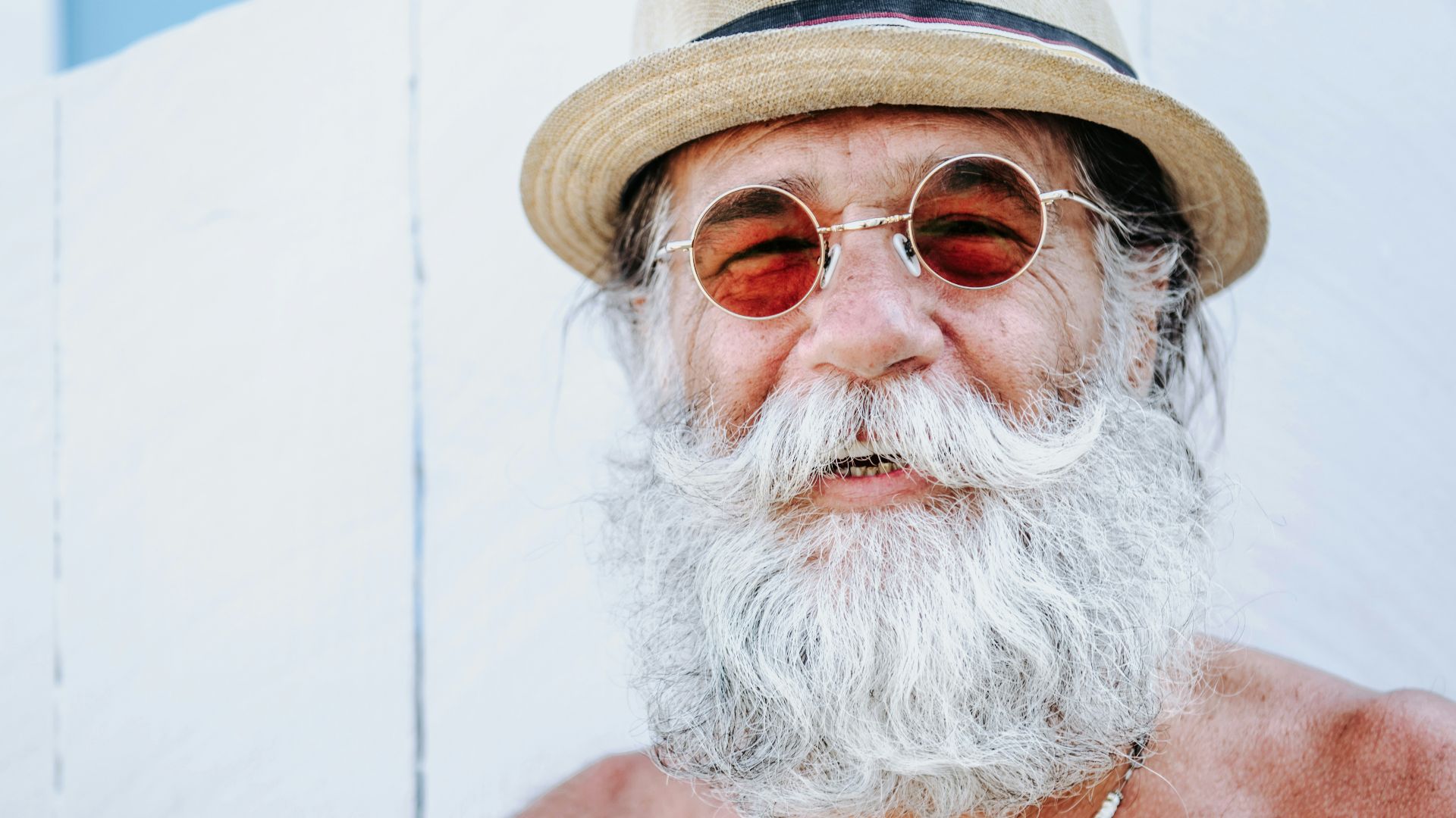 a man with a white beard and mustache wearing a hat