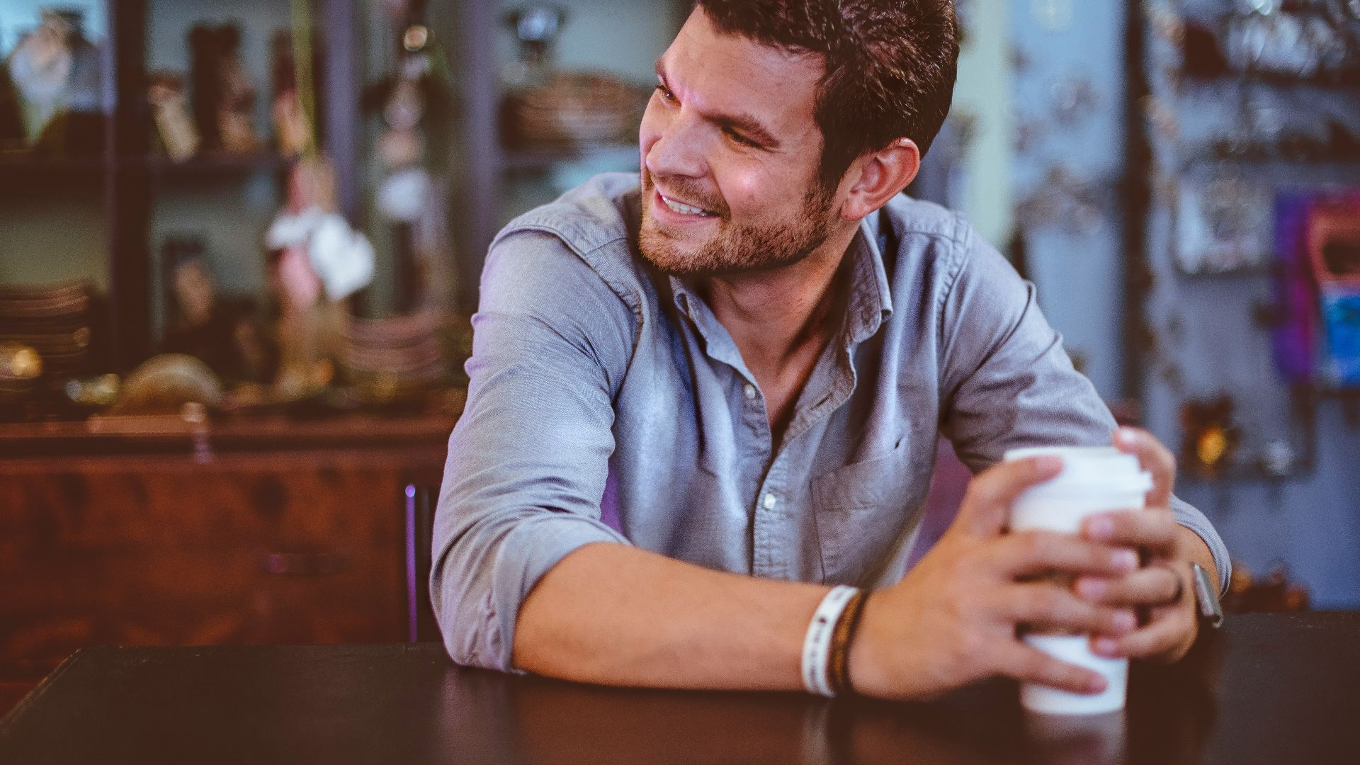 man holding cup on table