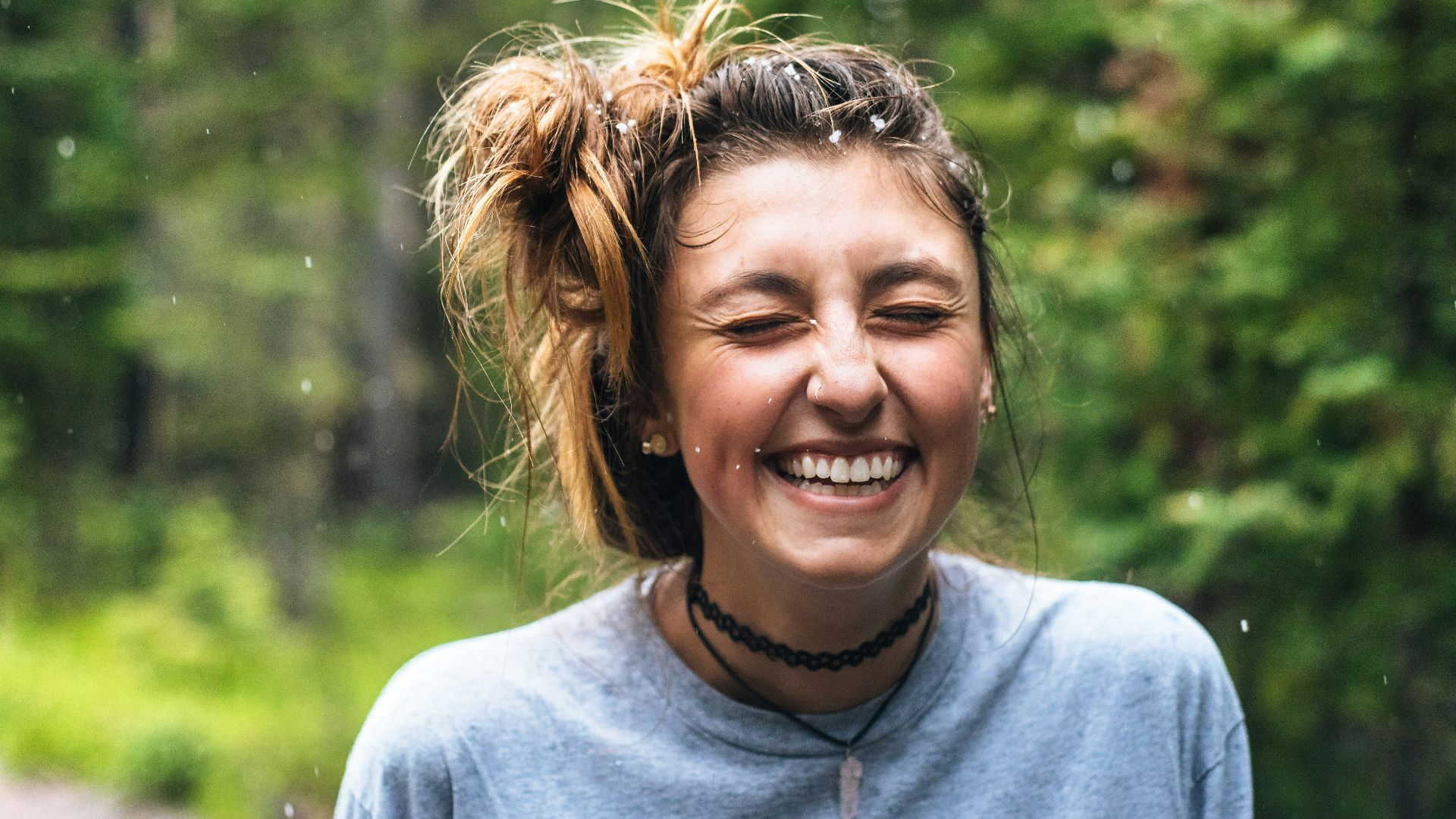 woman smiling near tree outdoor during daytime