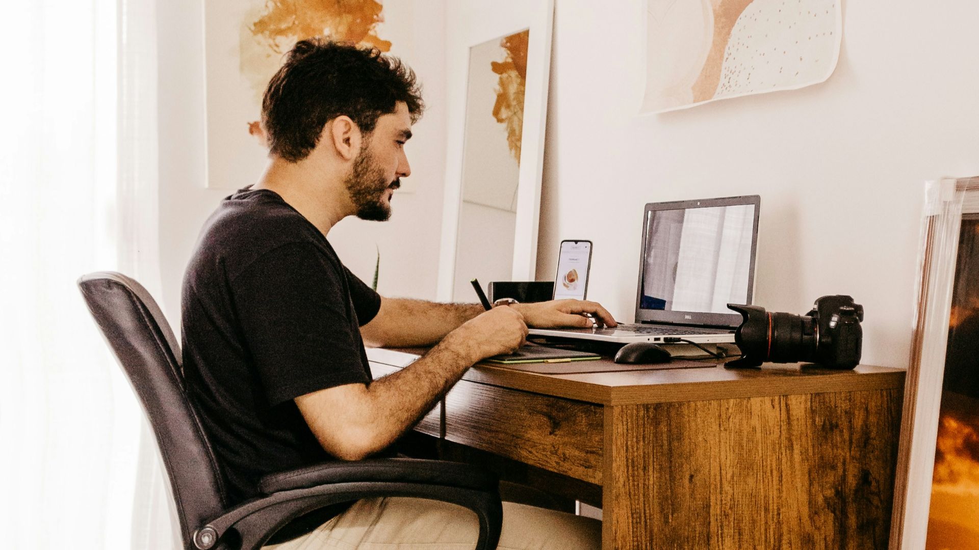 a man sitting at a desk working on a laptop