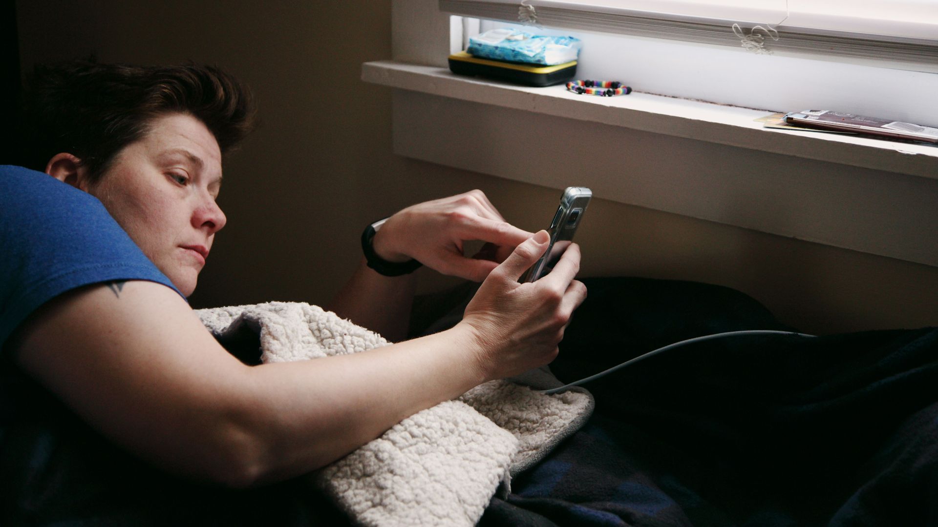 man in black shirt holding black smartphone