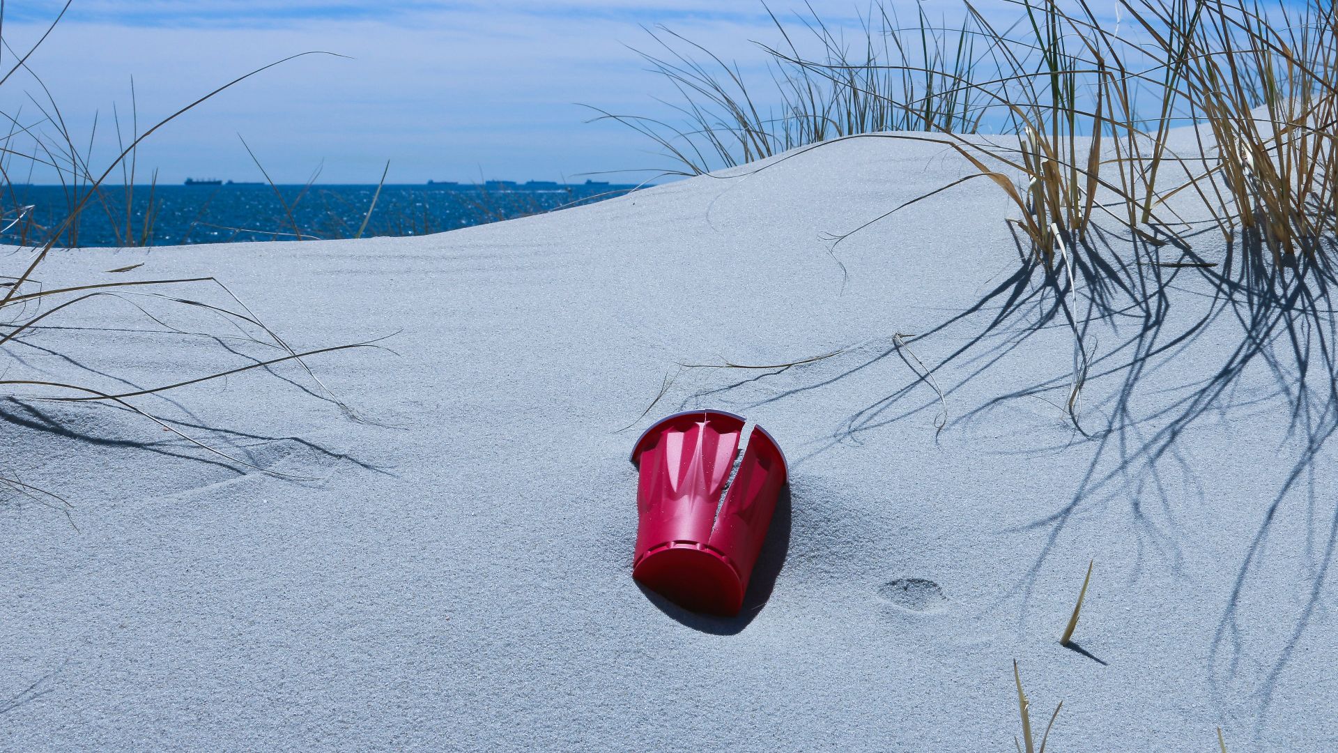 red plastic bucket on gray sand