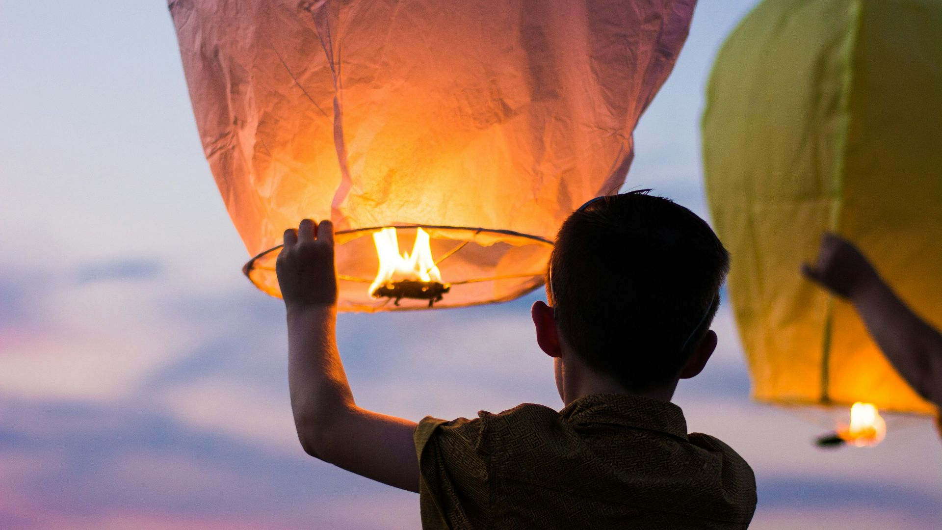 person holding yellow flammable balloon