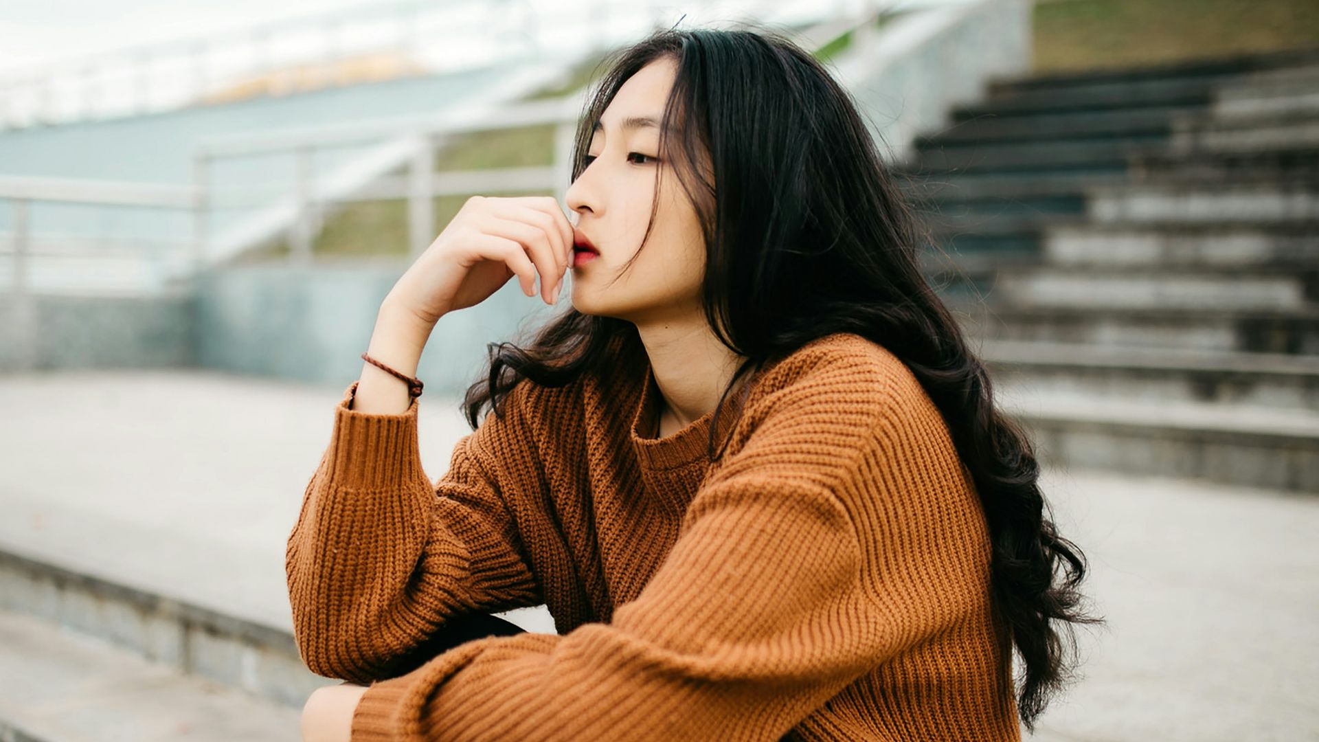woman wearing brown sweater holding lips