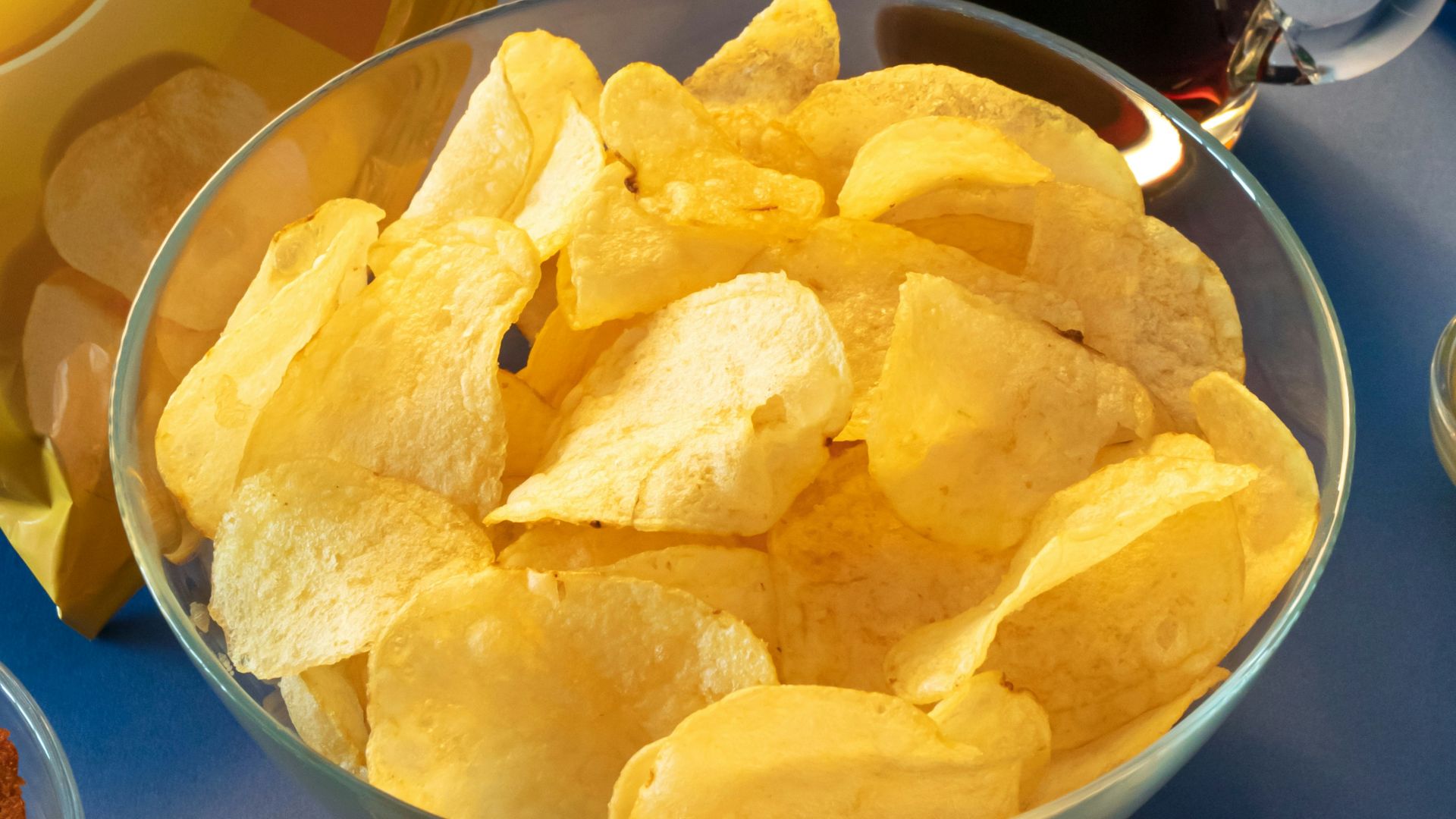 clear drinking glass beside brown bread on blue ceramic plate