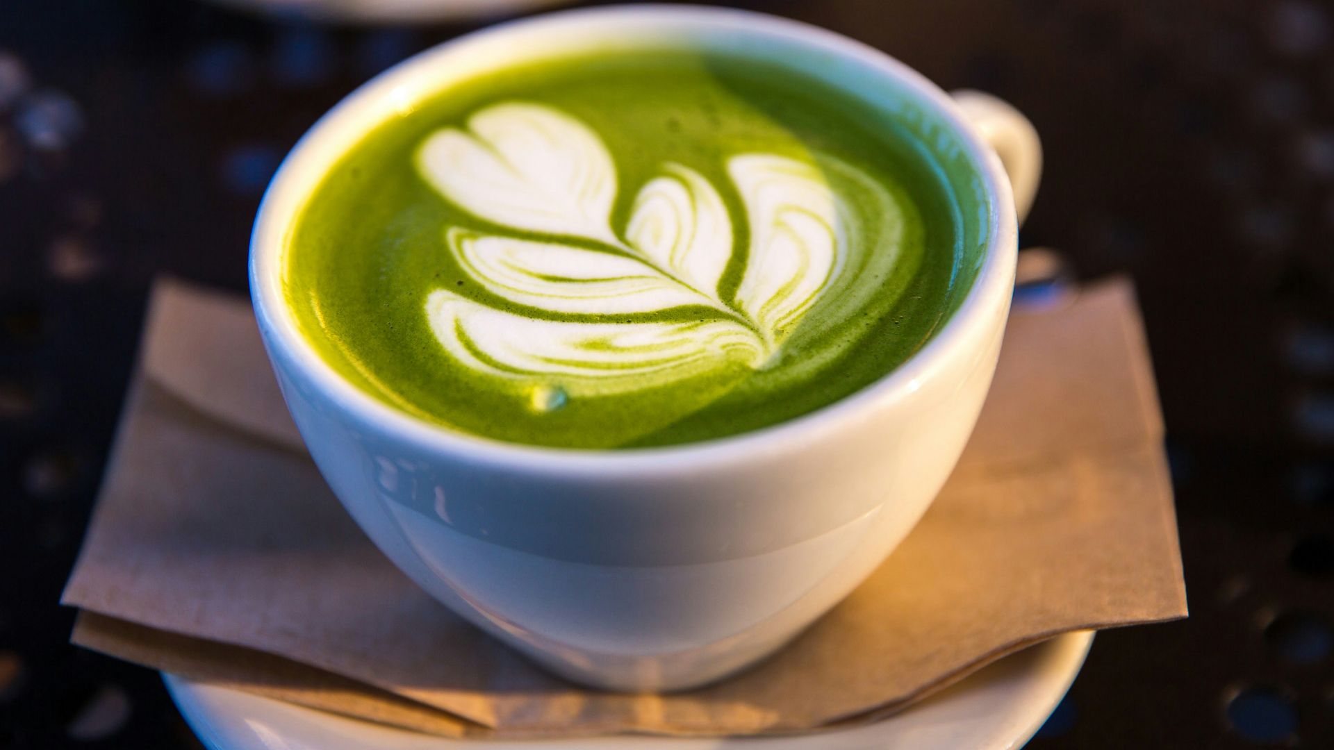 white ceramic teacup filled of matcha tea