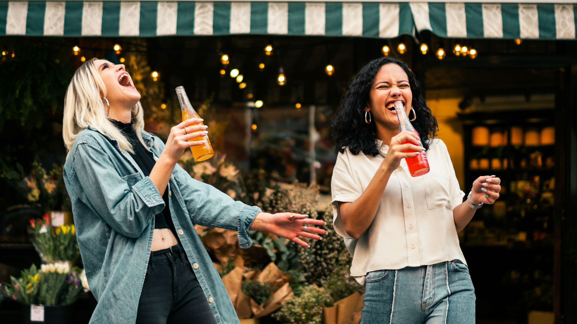 man in blue denim jacket holding clear drinking glass
