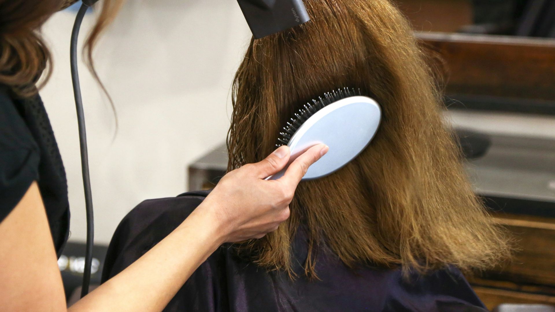 woman holding white and black hair blower