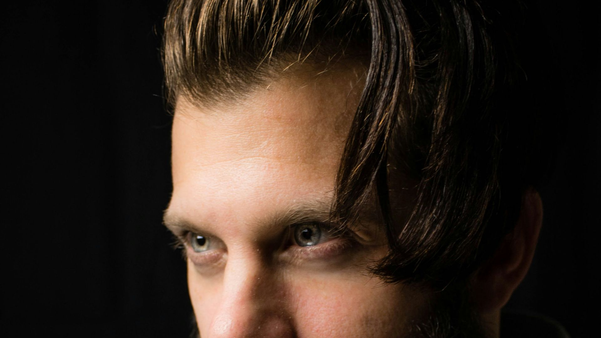 man with index finger on lips