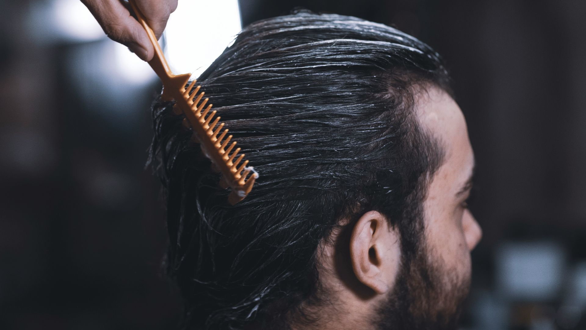 woman in white long sleeve shirt holding brown hair brush