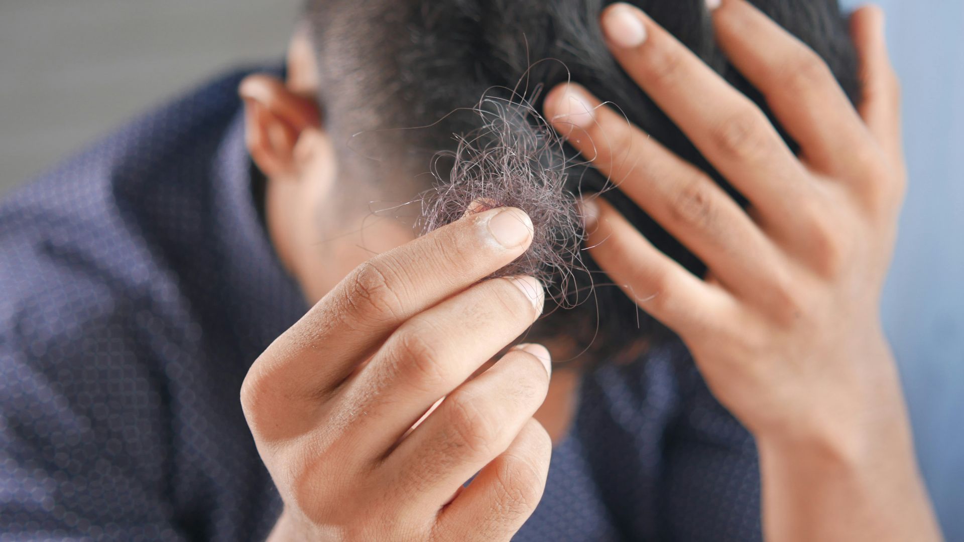 a man is combing his hair with his hands