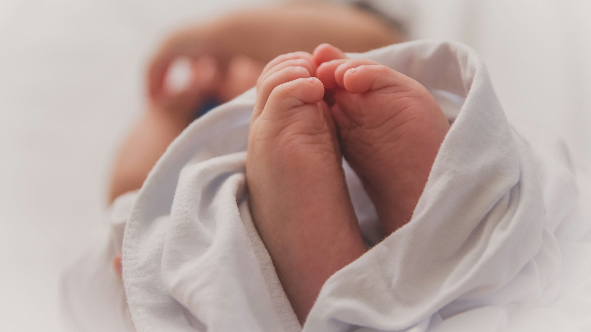 baby covered with white blanket