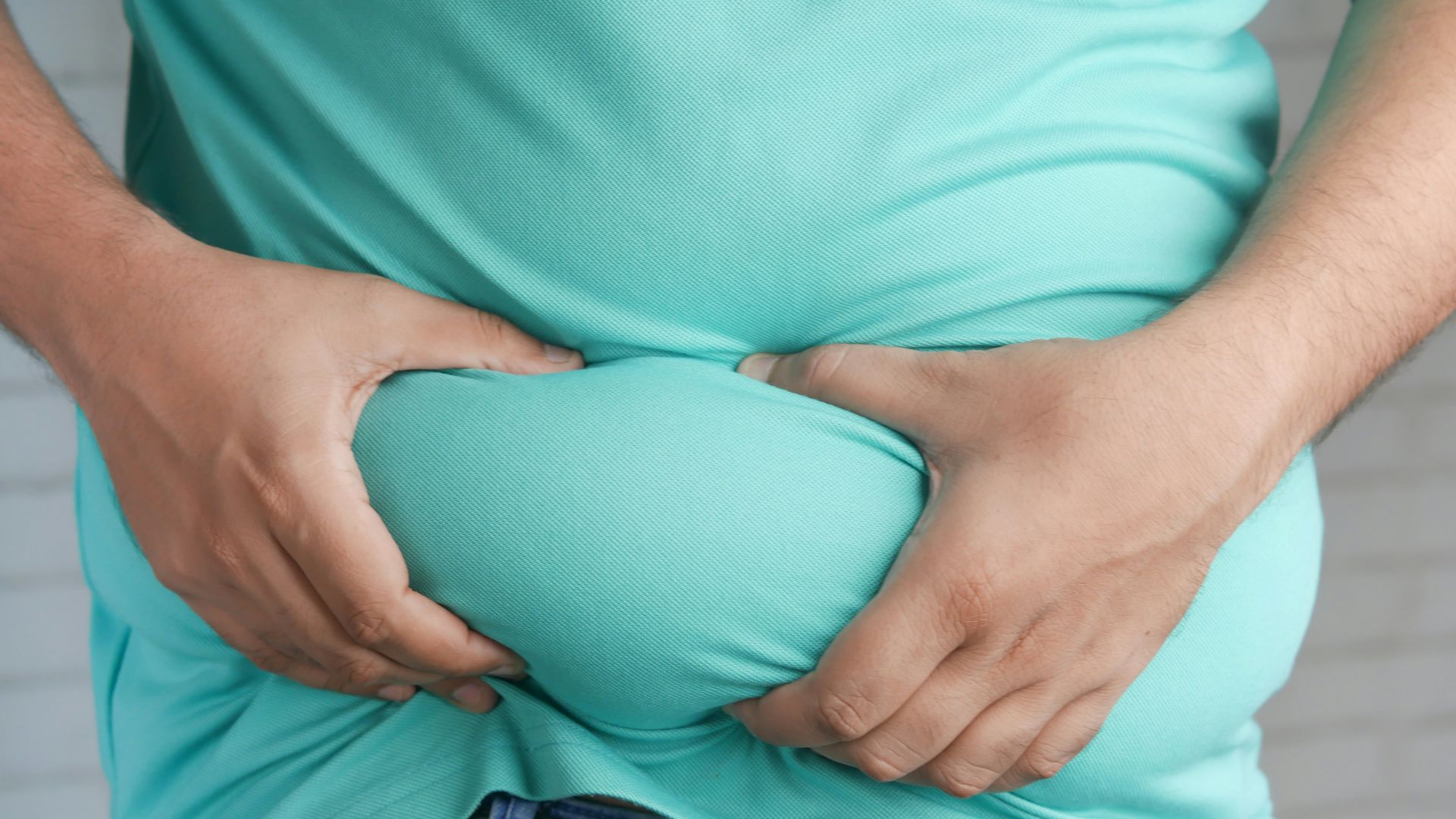 a man holding his stomach with his hands