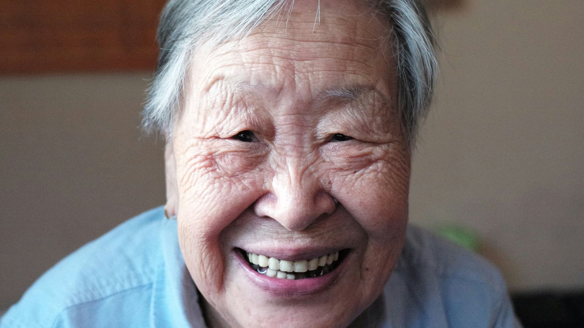 woman in blue button-down shirt smiling in front of camera