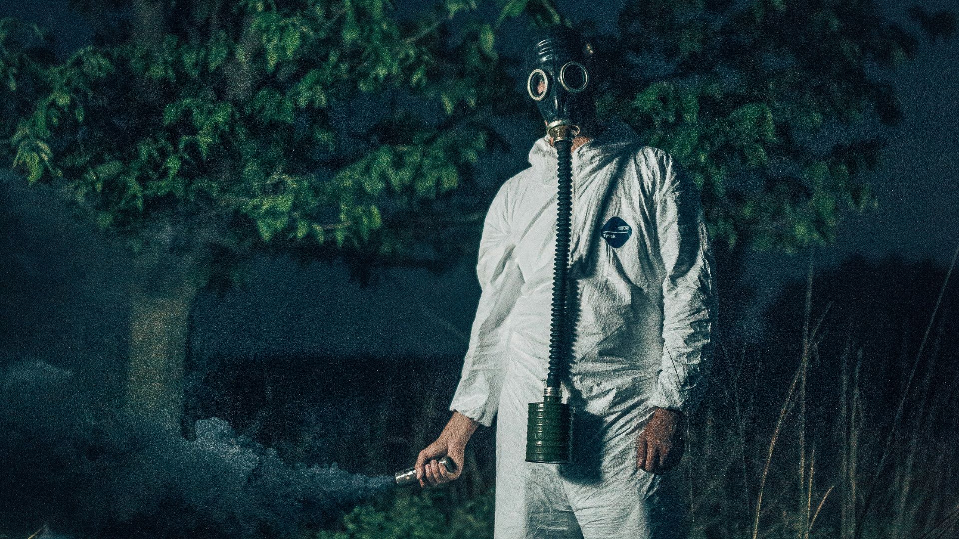 man in white zip up jacket and gray pants standing on green grass field during daytime