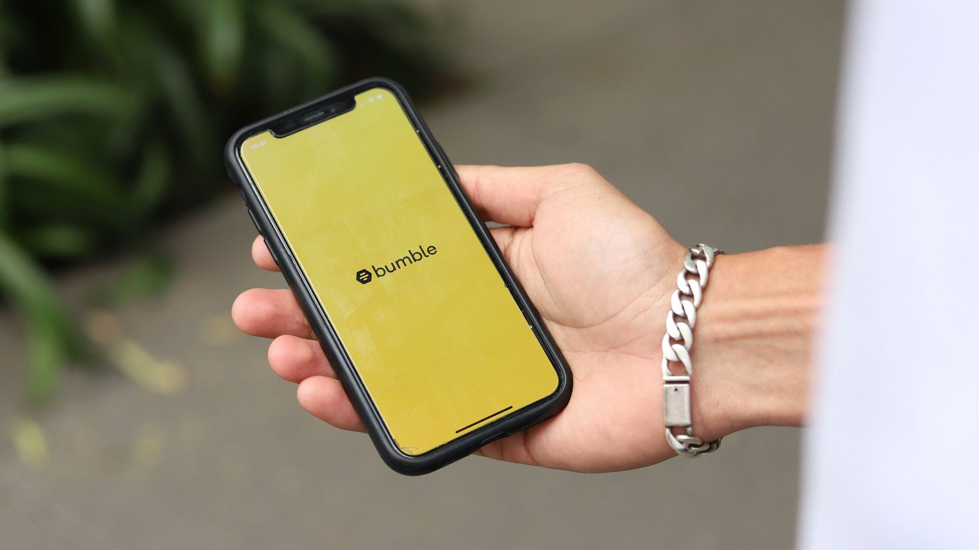 a person holding a yellow cell phone in their hand