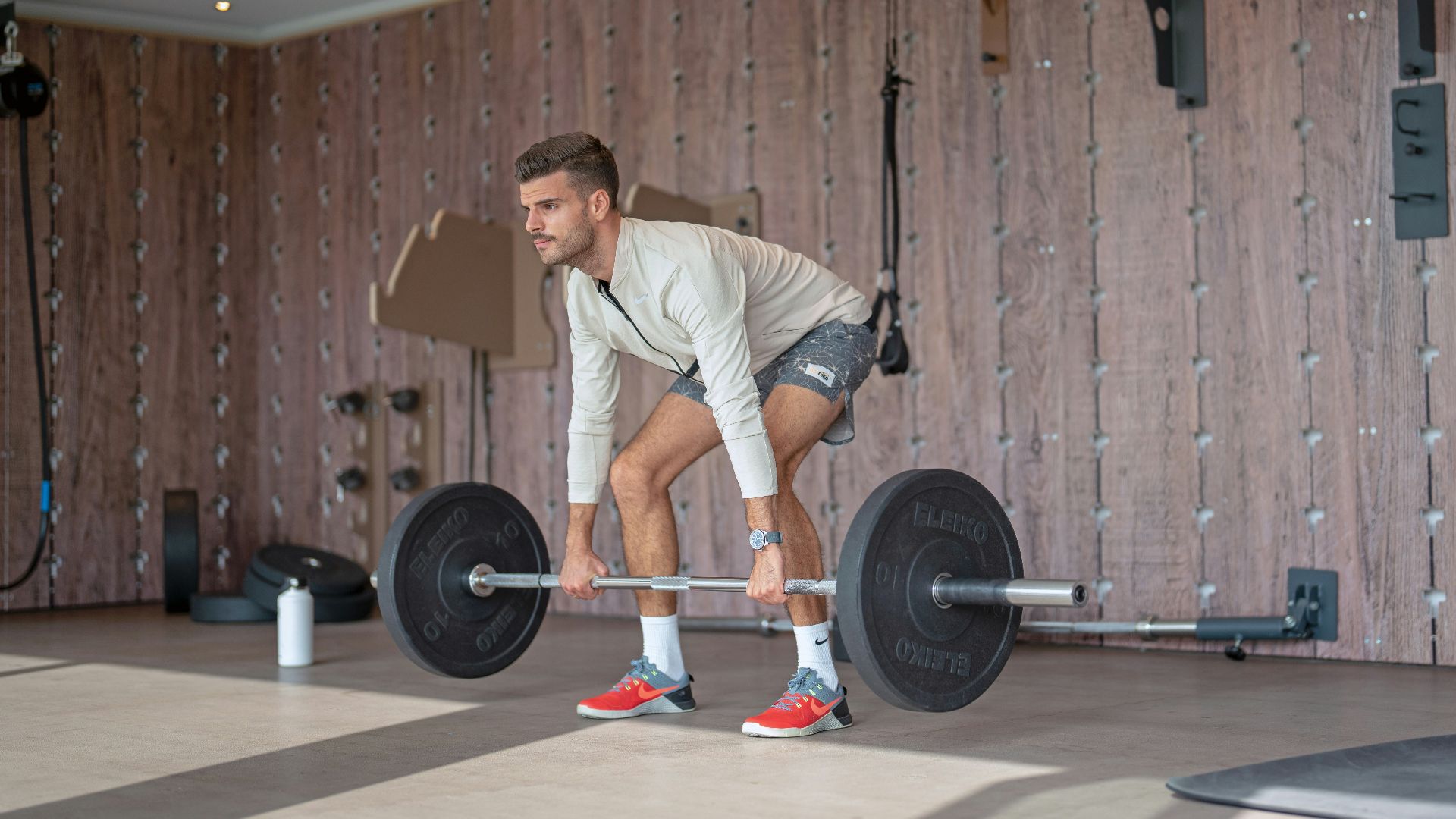 a man lifting a barbell in a gym