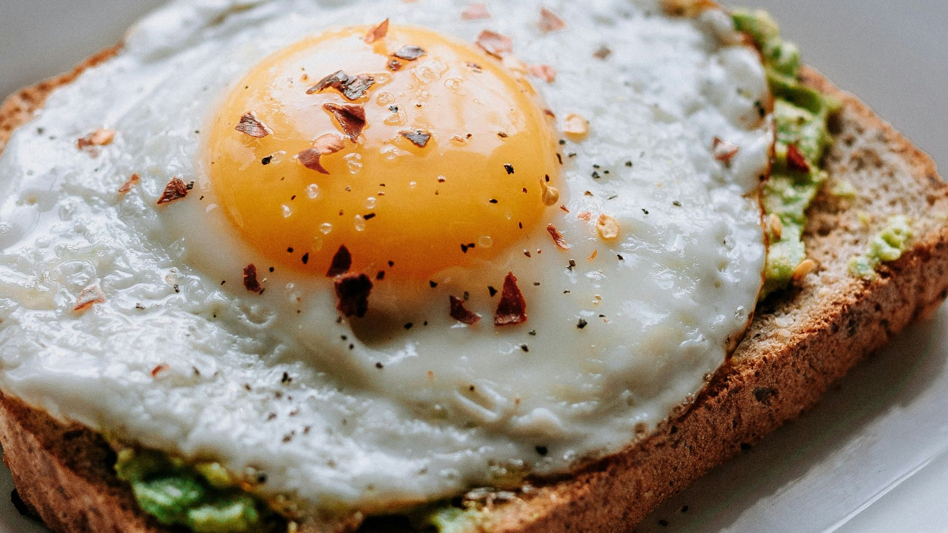 bread with sunny side-up egg served on white ceramic plate