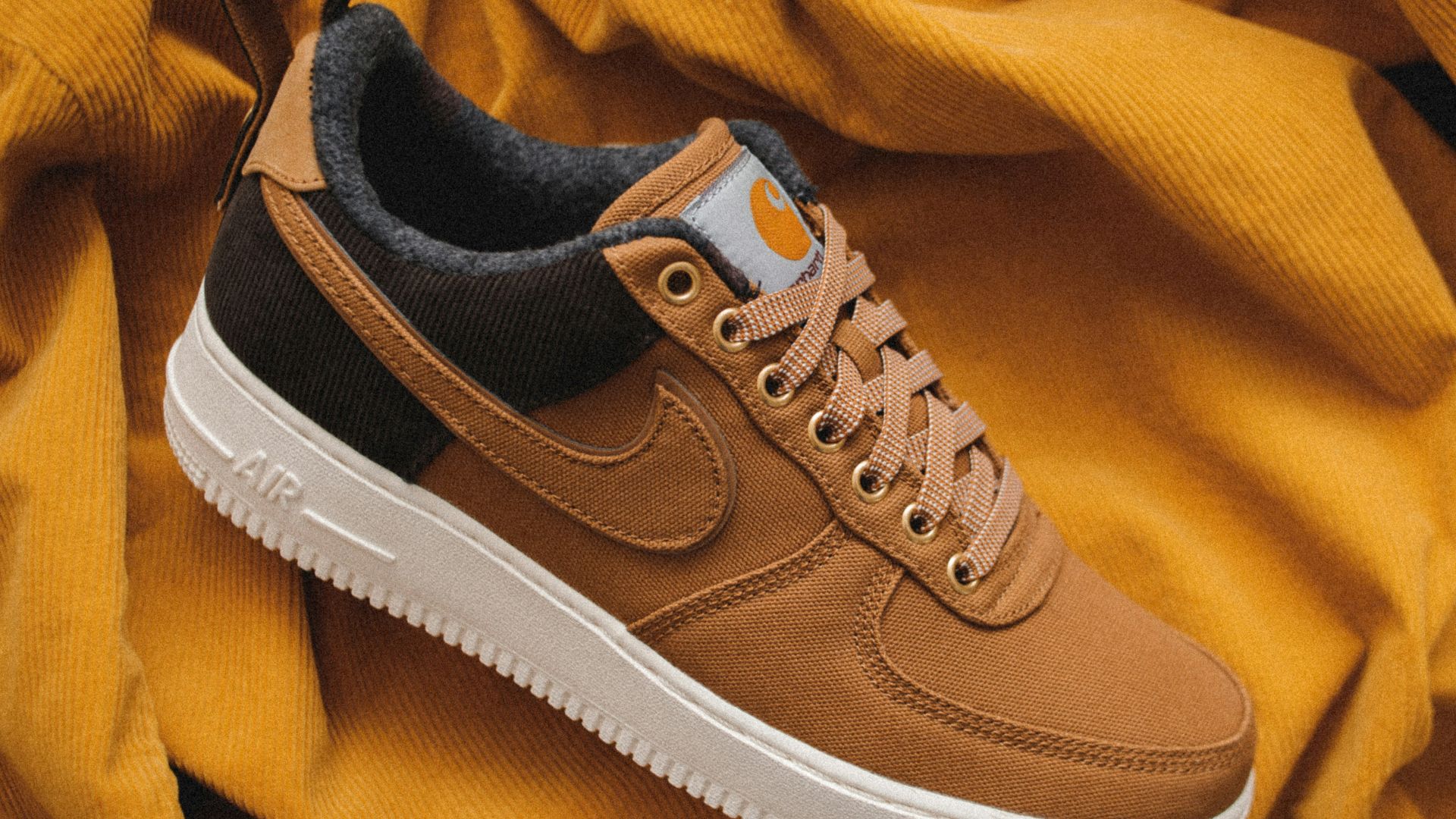 brown Nike sneaker on yellow textile