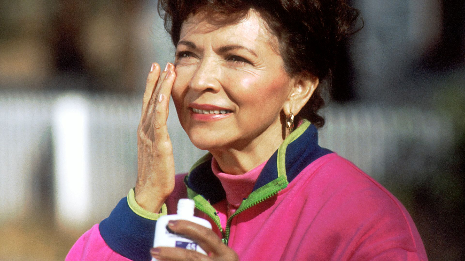 smiling woman in pink and blue shirt