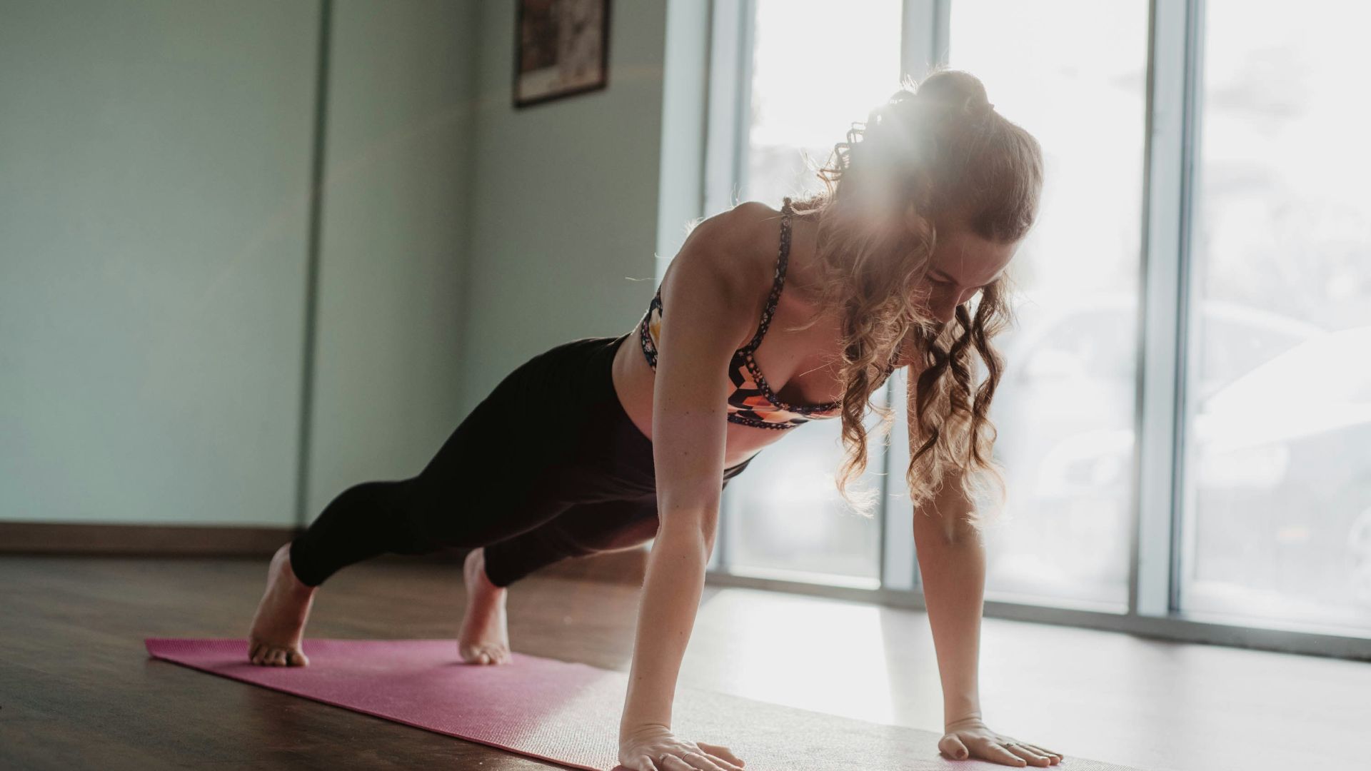 woman in black tank top and black leggings doing yoga
