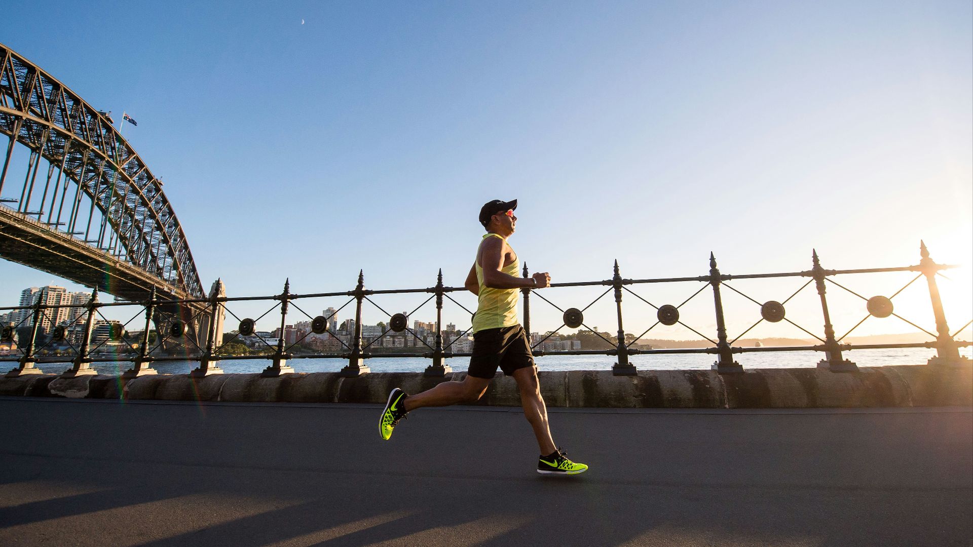 man in yellow tank top running near shore