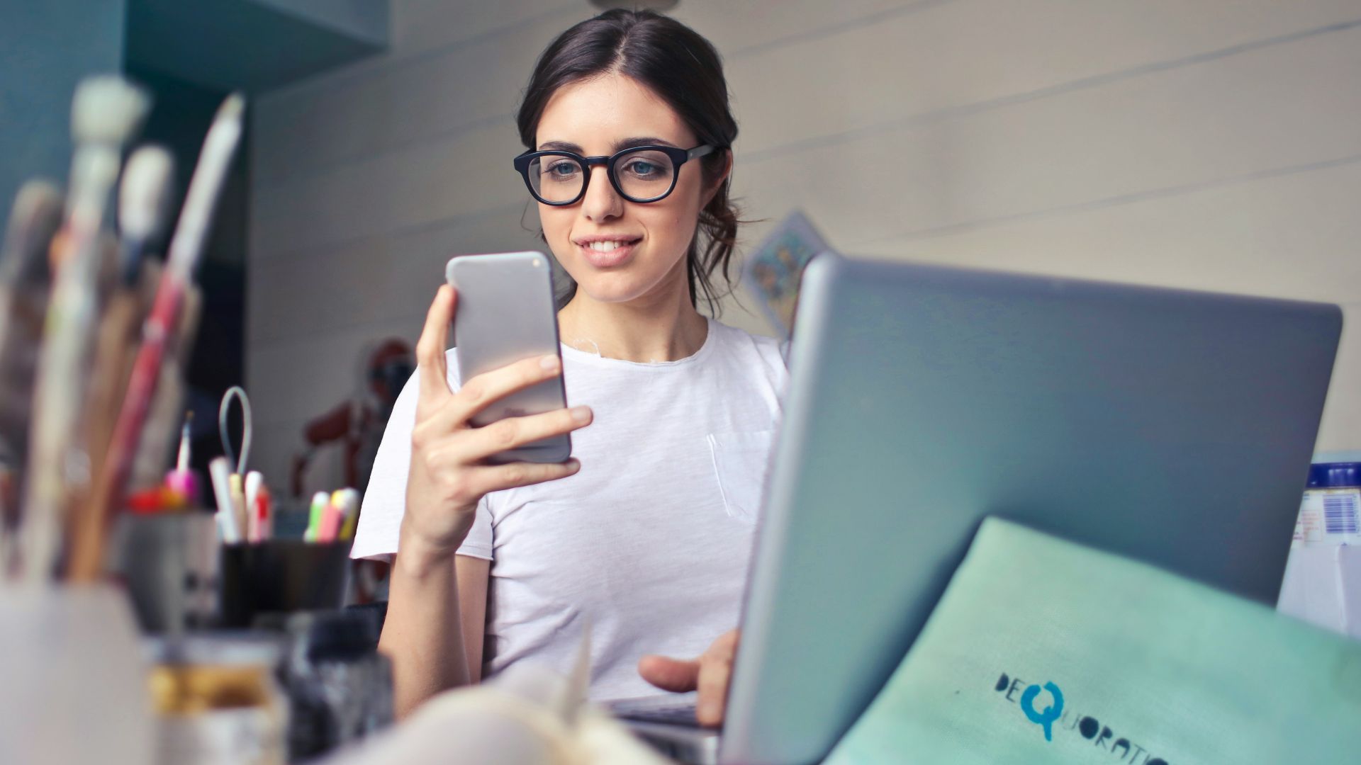 woman in white shirt using smartphone