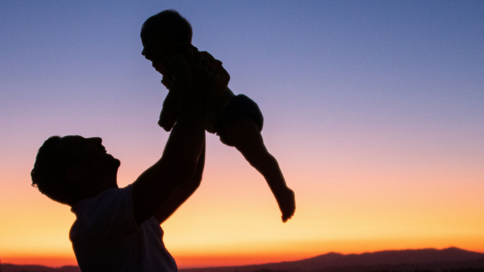 silhouette of man and woman kissing during sunset