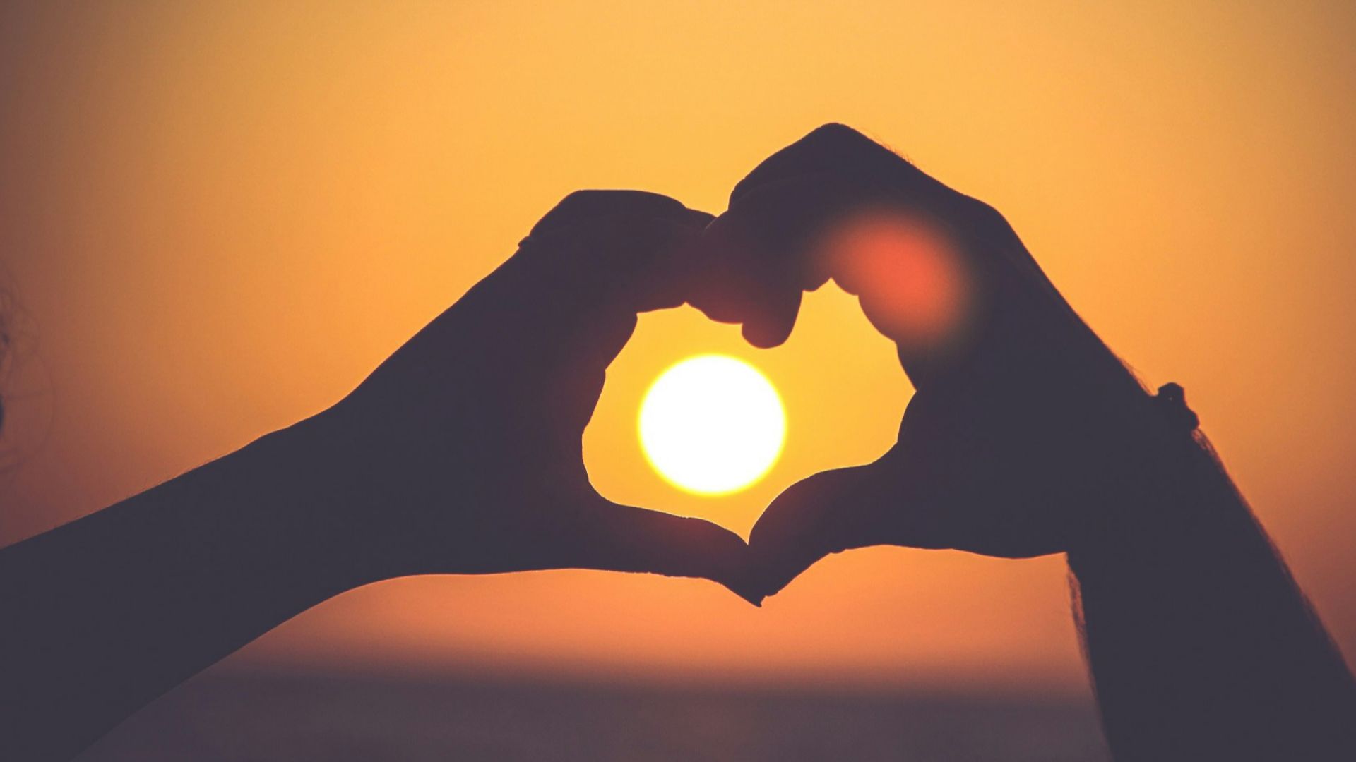 silhouette of person's hands forming heart