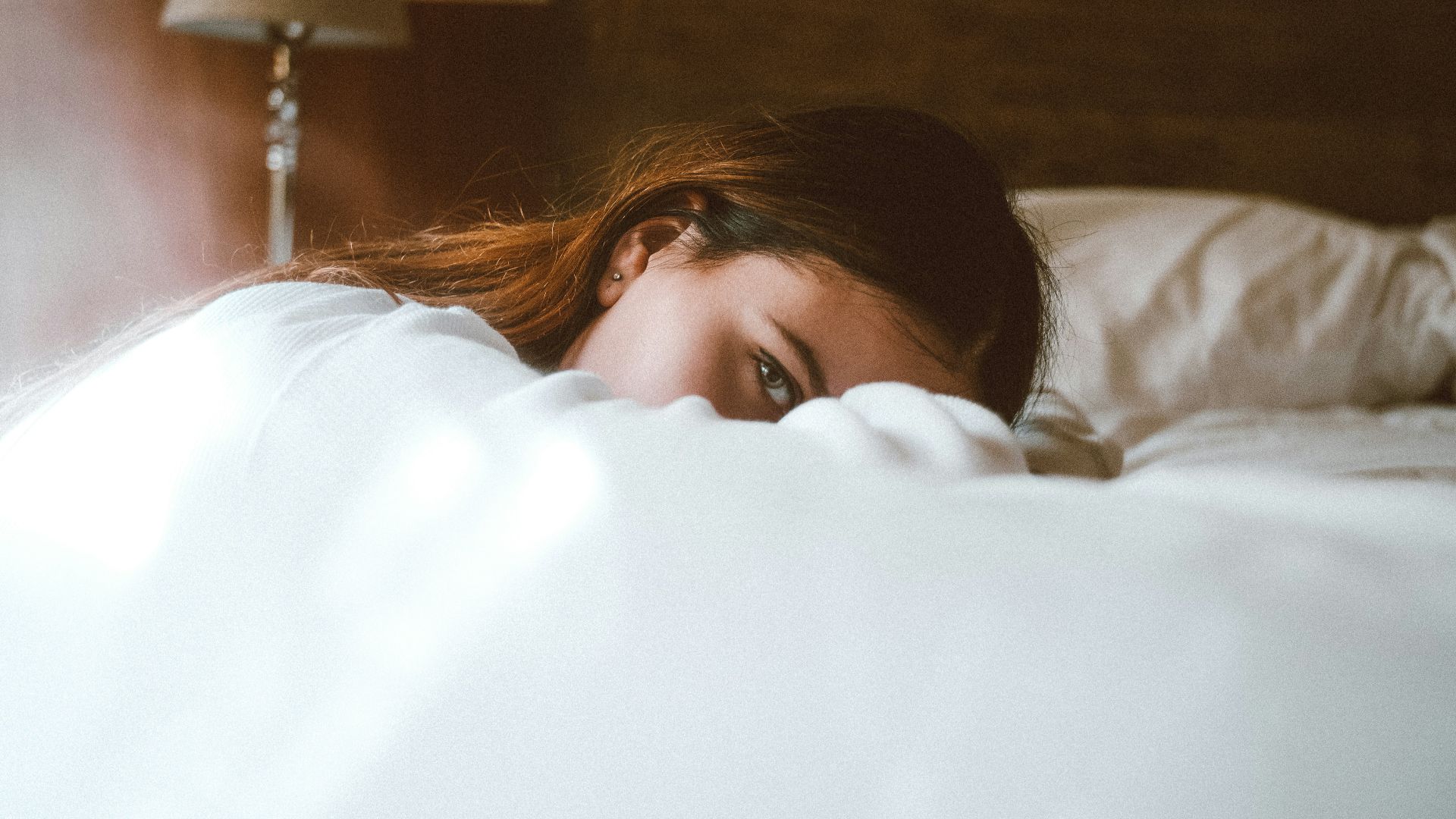 woman resting her head on bed